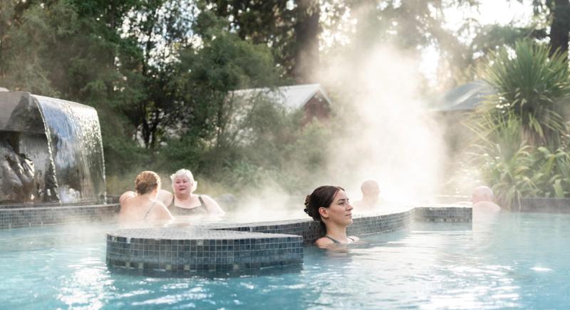 A woman's hand delicately touches the thermal water at Hanmer Springs