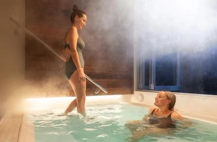 Two young ladies enjoying the Elemental Private geothermal pools smiling at each otehr