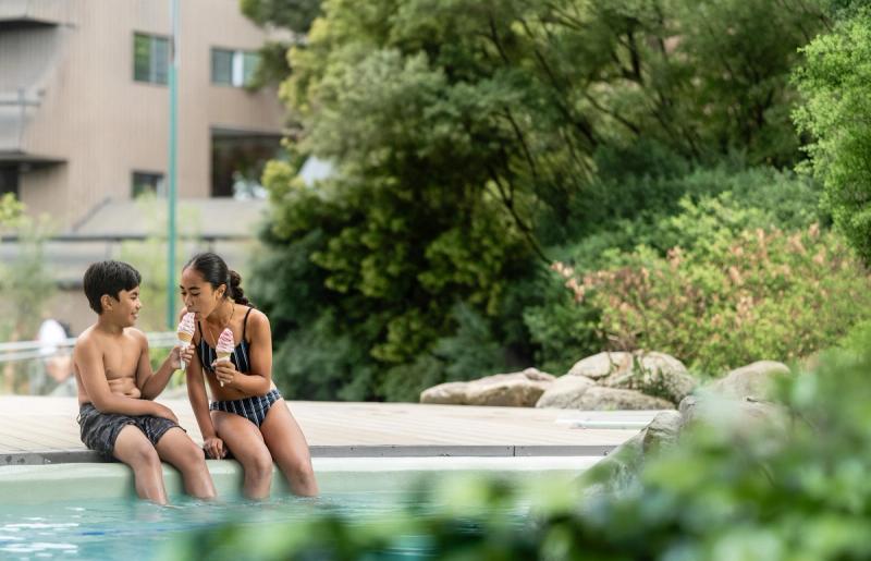 Brother and sister enjoying an ice cream together poolside at the cafe Hanmer Springs