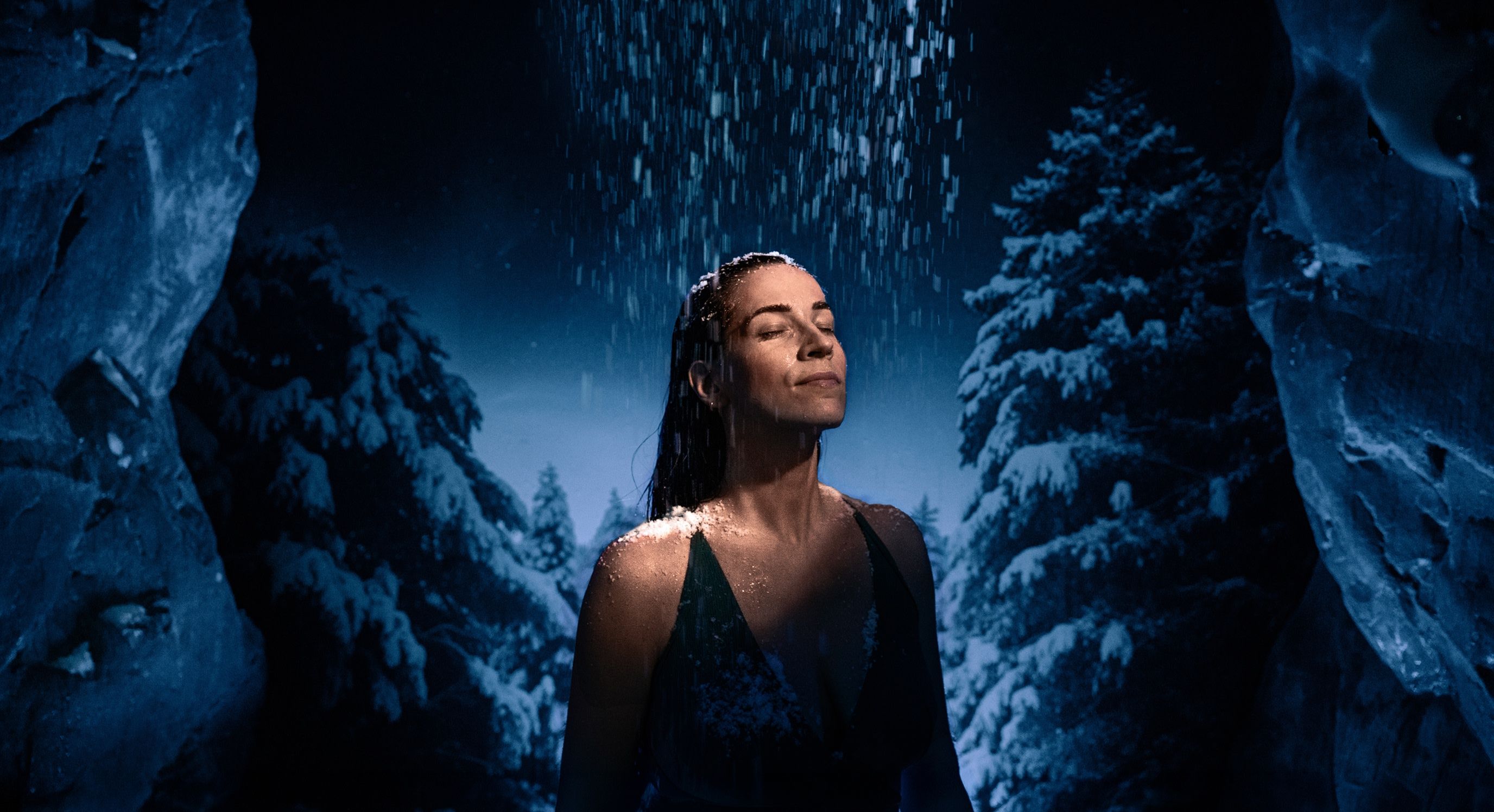 Lady under the snow in the Glacial room of Elemental, snow falling on her head, face and shoulders