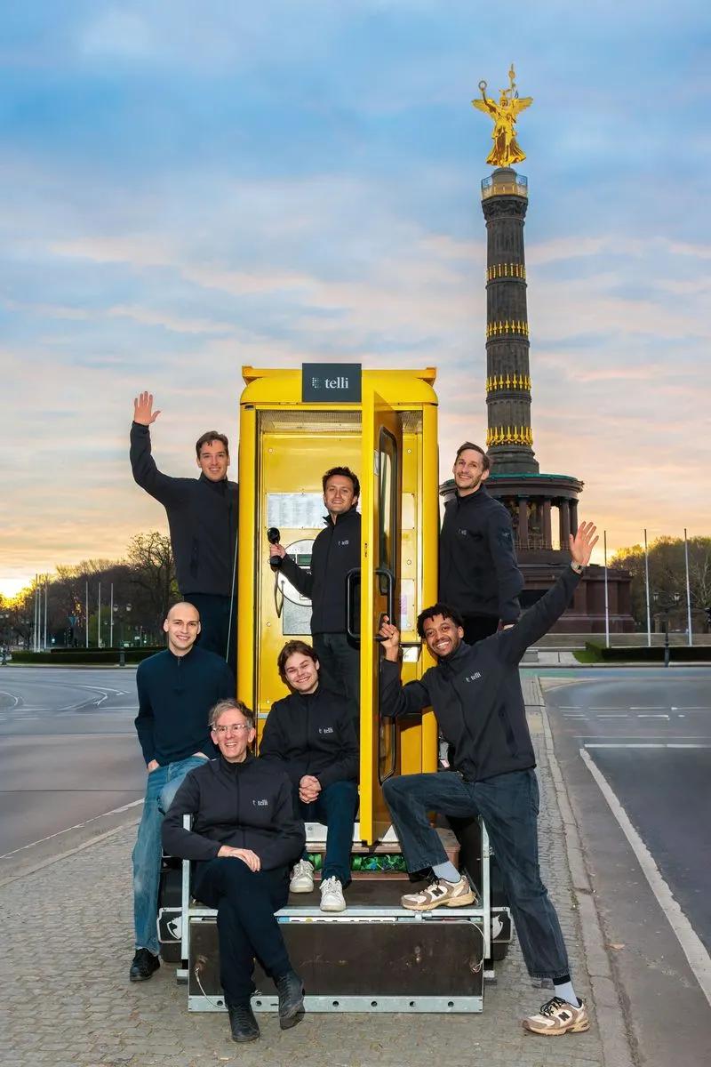 telli founders Seb, Finn, and Philipp beside a yellow phone booth