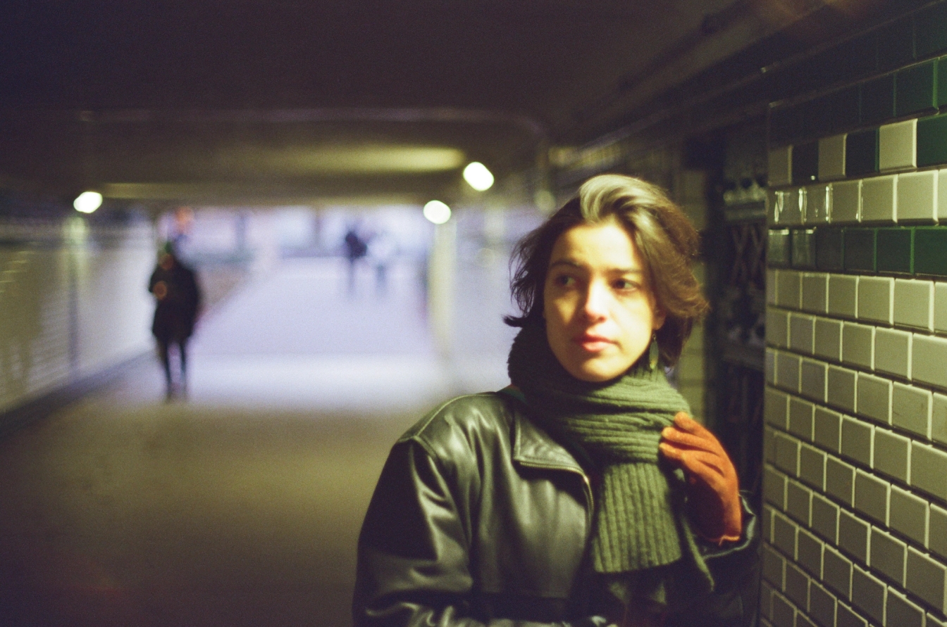 Cinematic looking photo of a beautiful woman in an underground tunnel, with an out of focus background. Front focused.