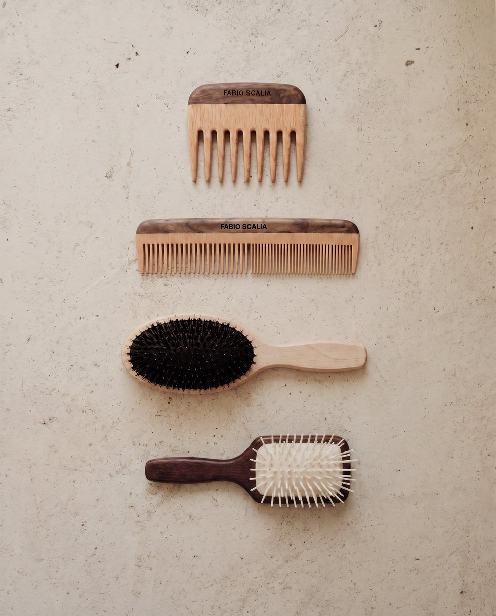 Fabio Scalia combs and brushes arranged on a textured plaster surface