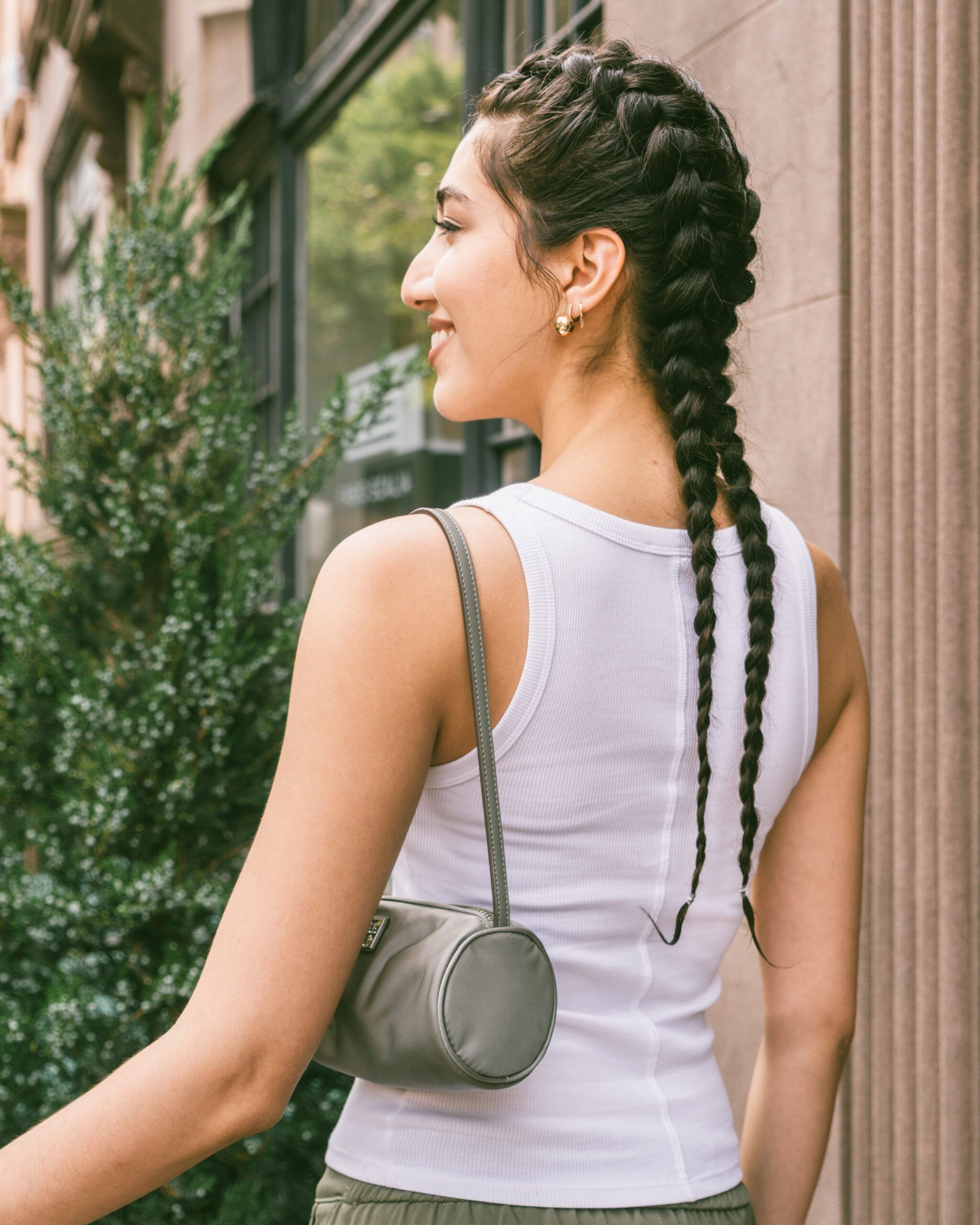 Model wearing sleek boxer braids, a protective workout hairstyle that keeps hair secure and stylish.