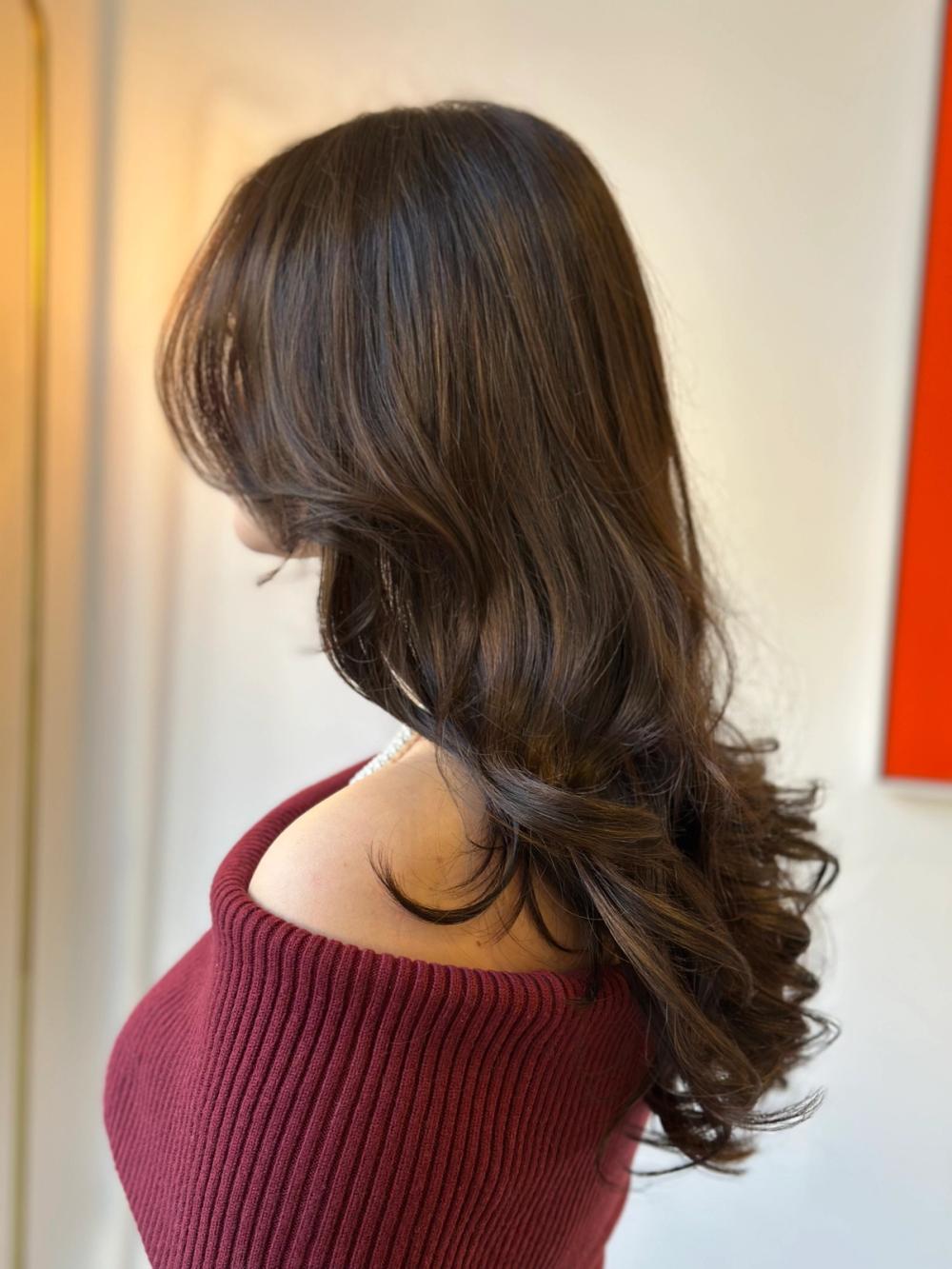 model with long layer haircut and rich earth tone color