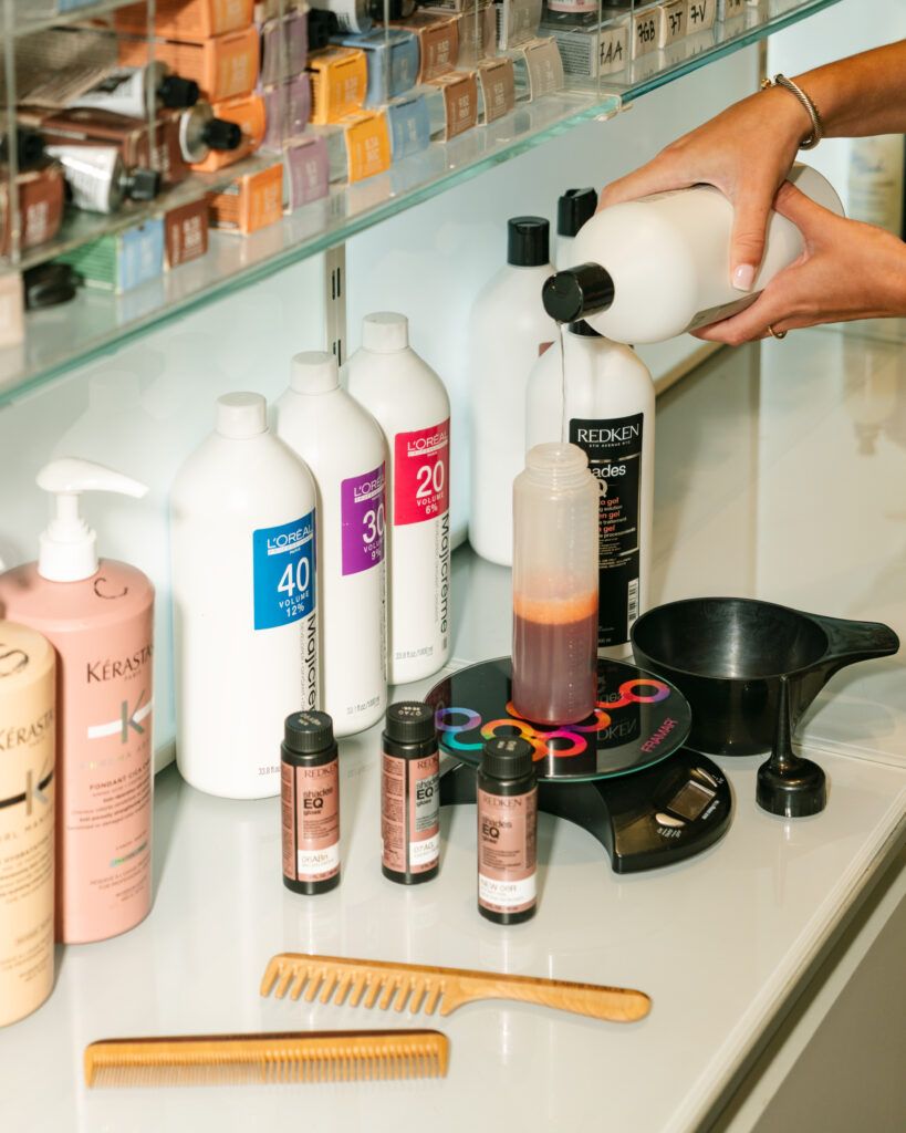 Stylist mixing professional hair gloss color at Fabio Scalia Salon in NYC for customized shine and tone