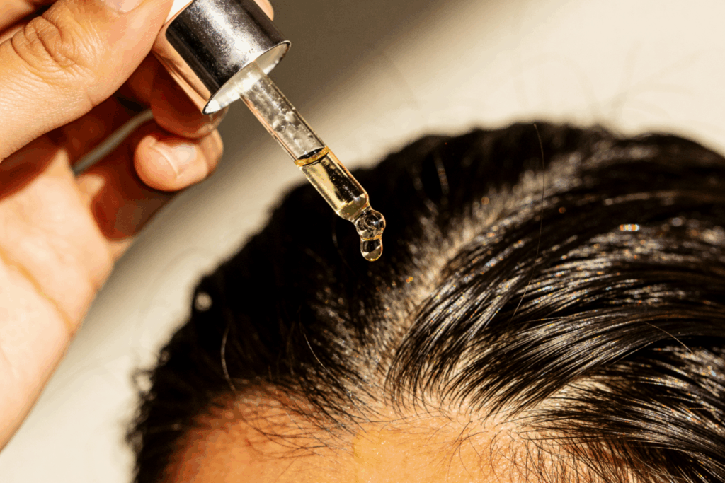 Close-up of scalp serum being applied with a dropper to support scalp health and hair strength