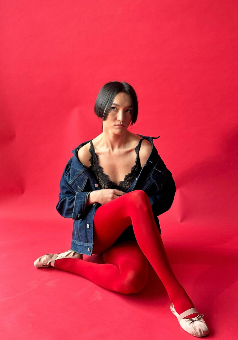 model wearing hime haircut wearing Miu Miu against a red backdrop 