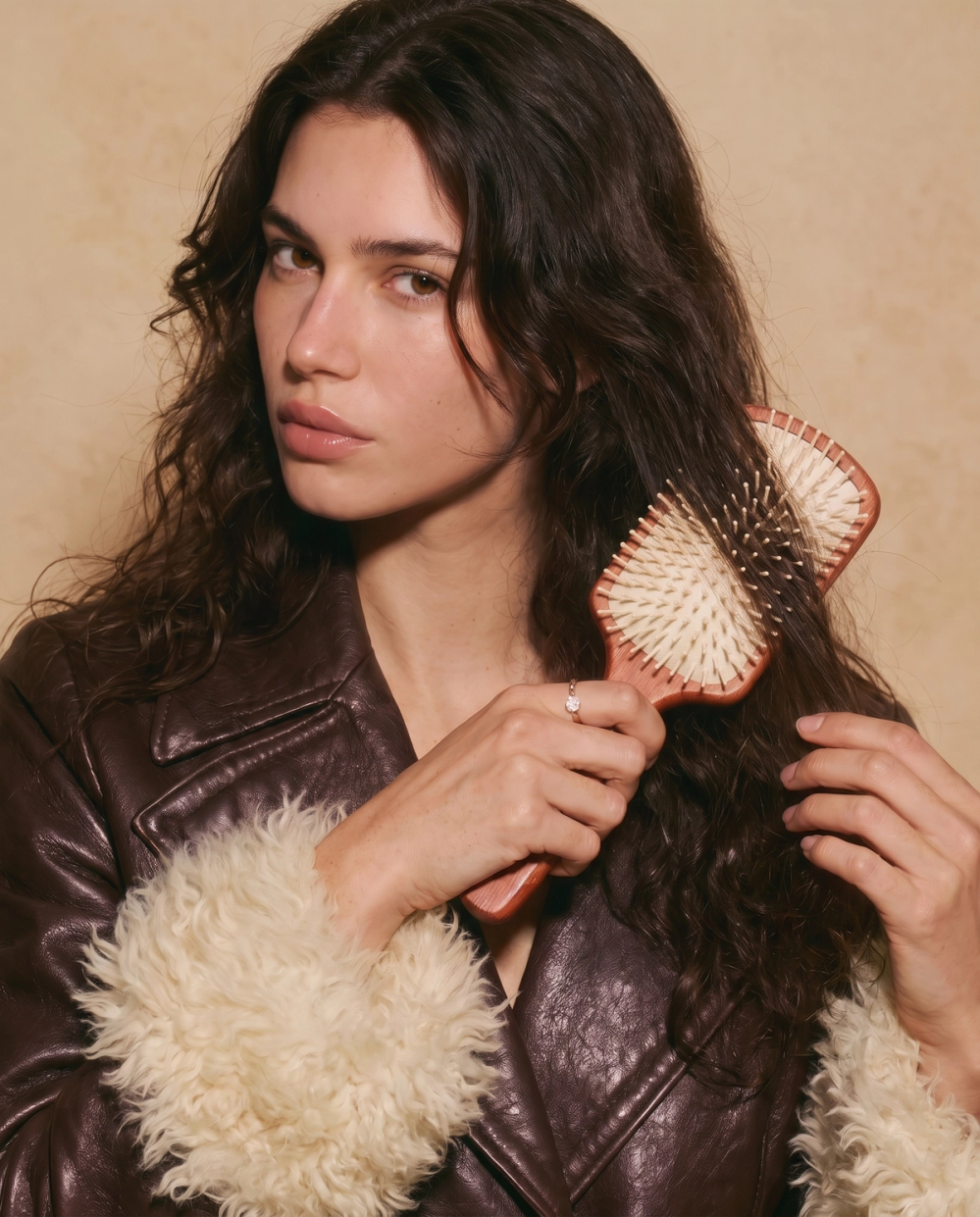 model brushing her hair with detangling brush