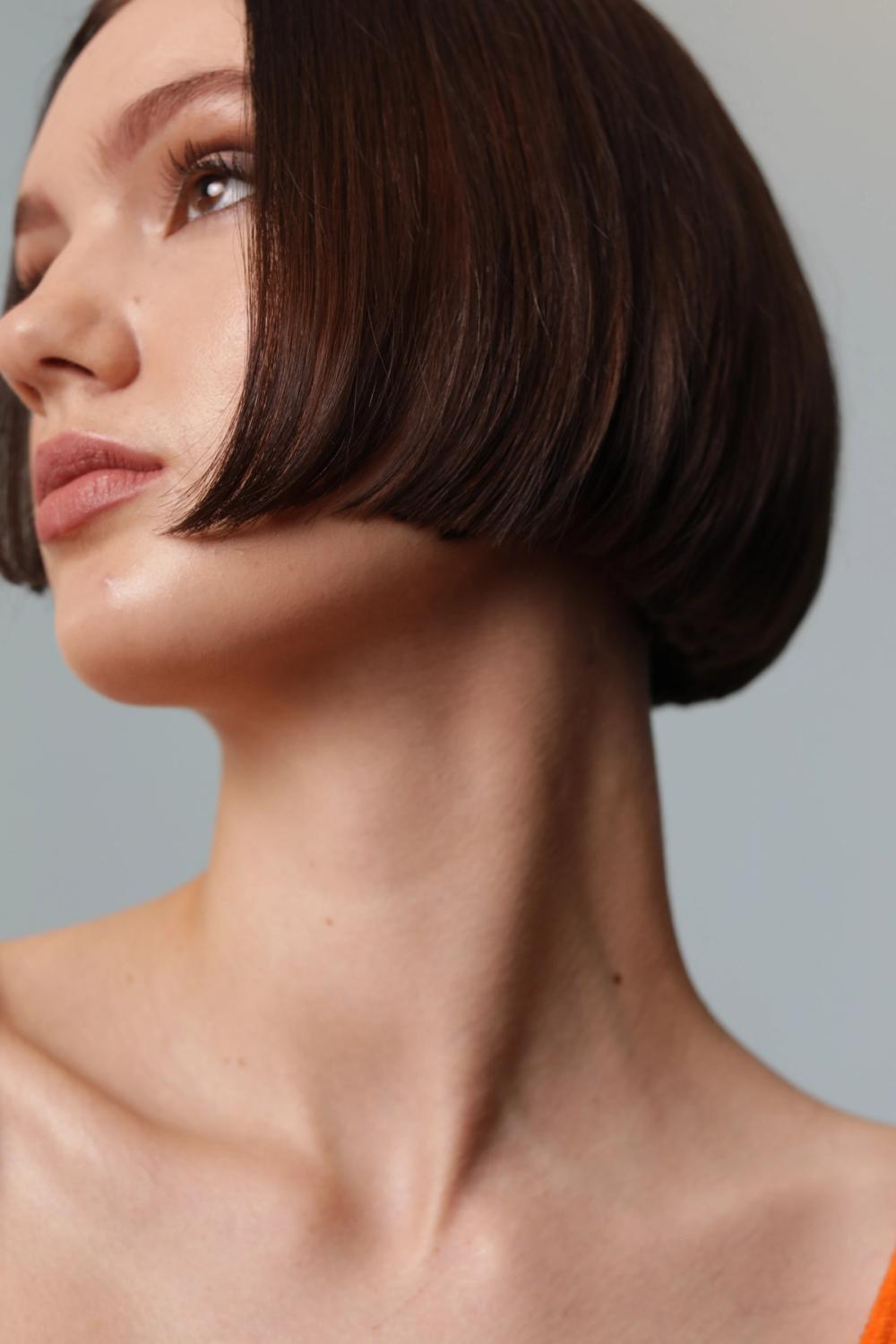 model sporting short chin length bob with dark brunette rich color finish