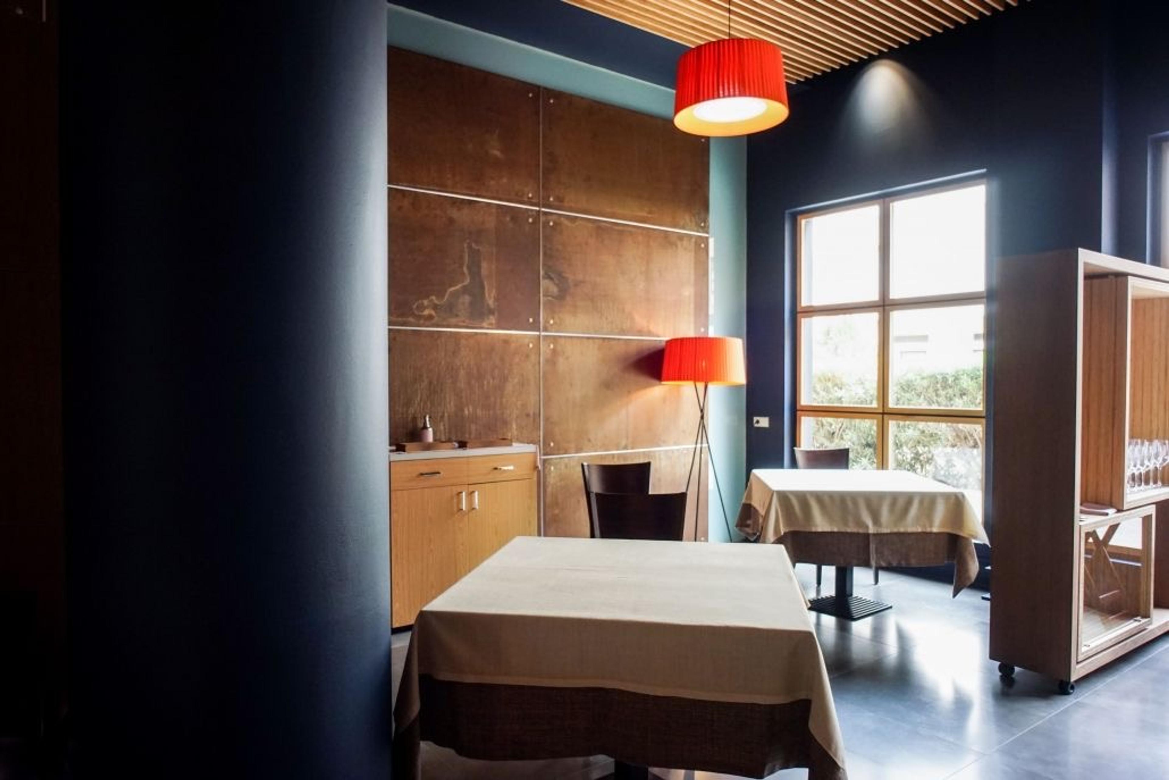 The dining room at Abantal, set tables by a tall window