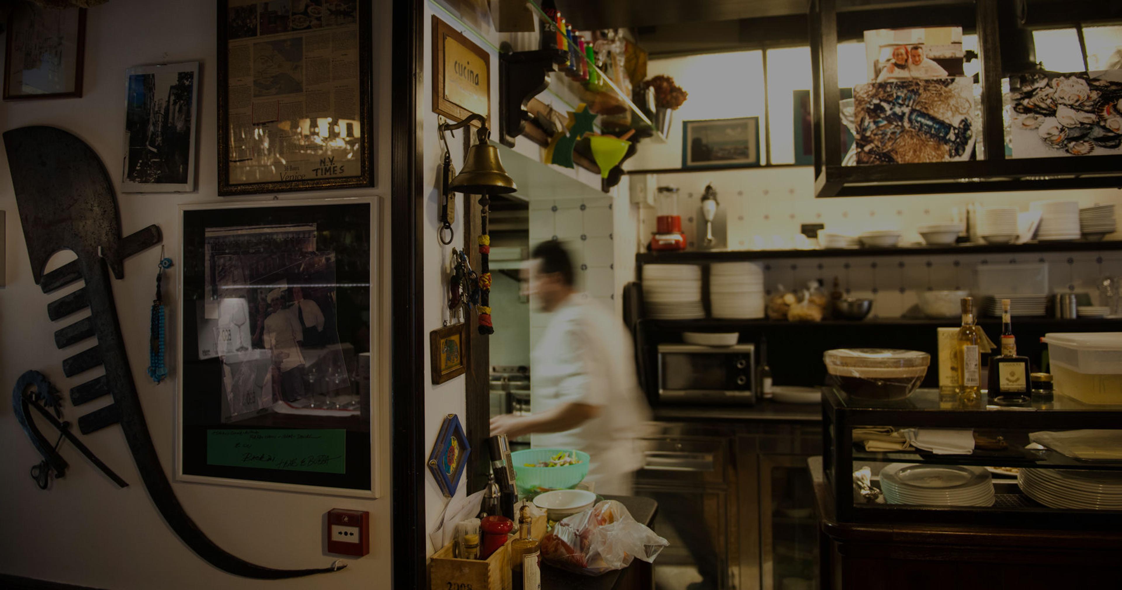 A narrow, dimly lit dining room with framed pictures on the walls