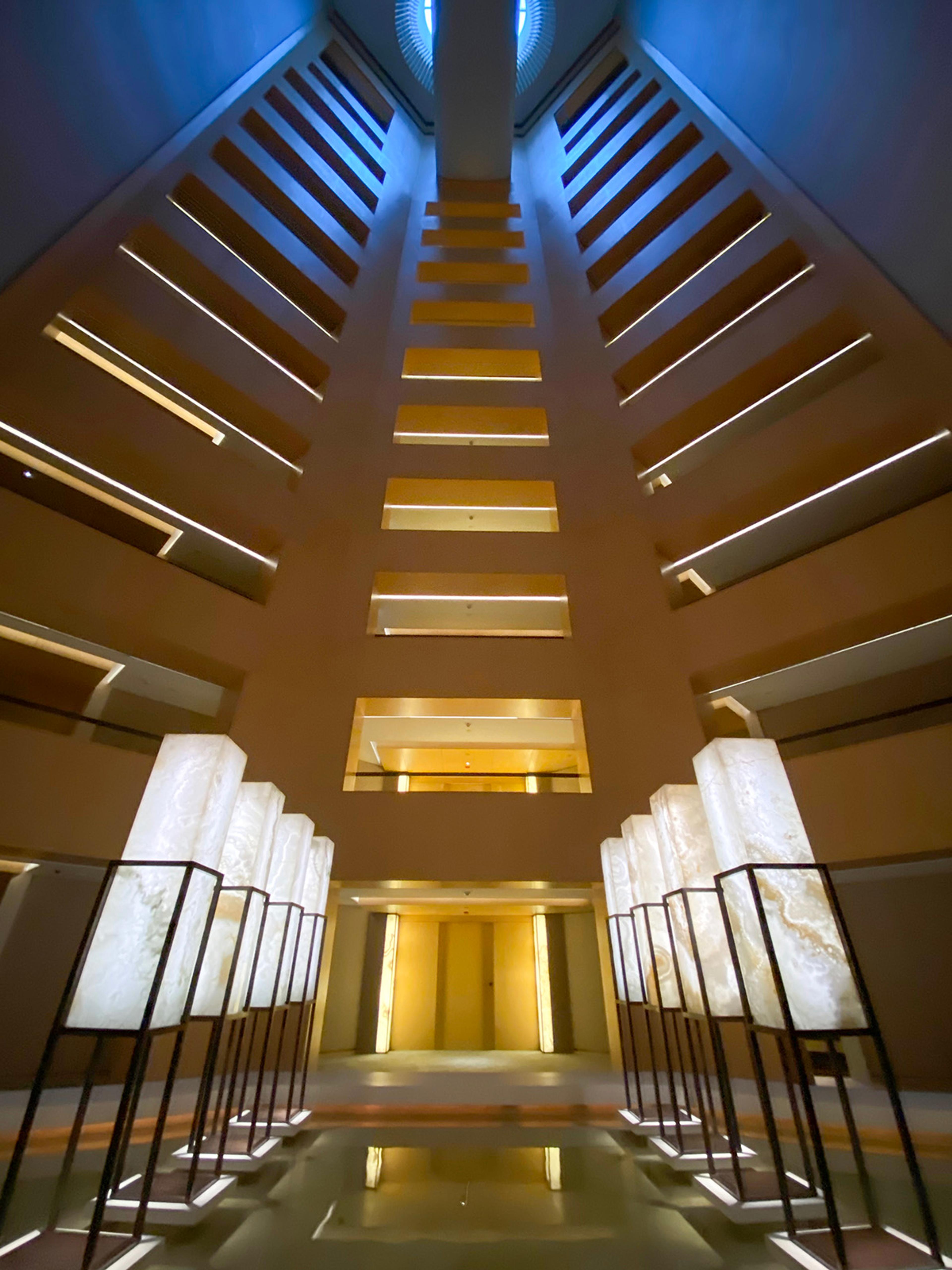 Looking up through the hotel's tall central void, ringed with lit balconies