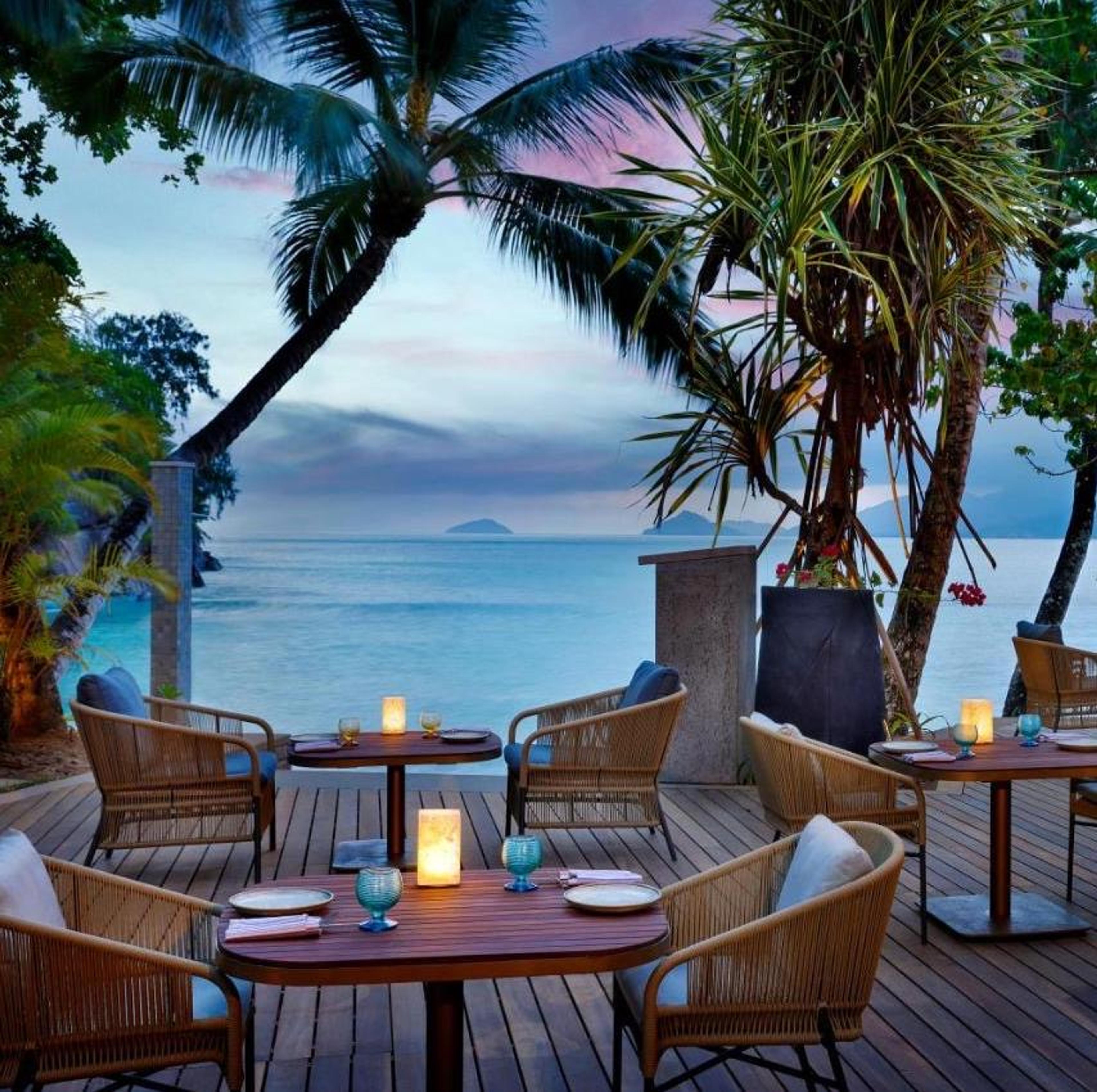 A restaurant terrace under the palms, looking out to sea