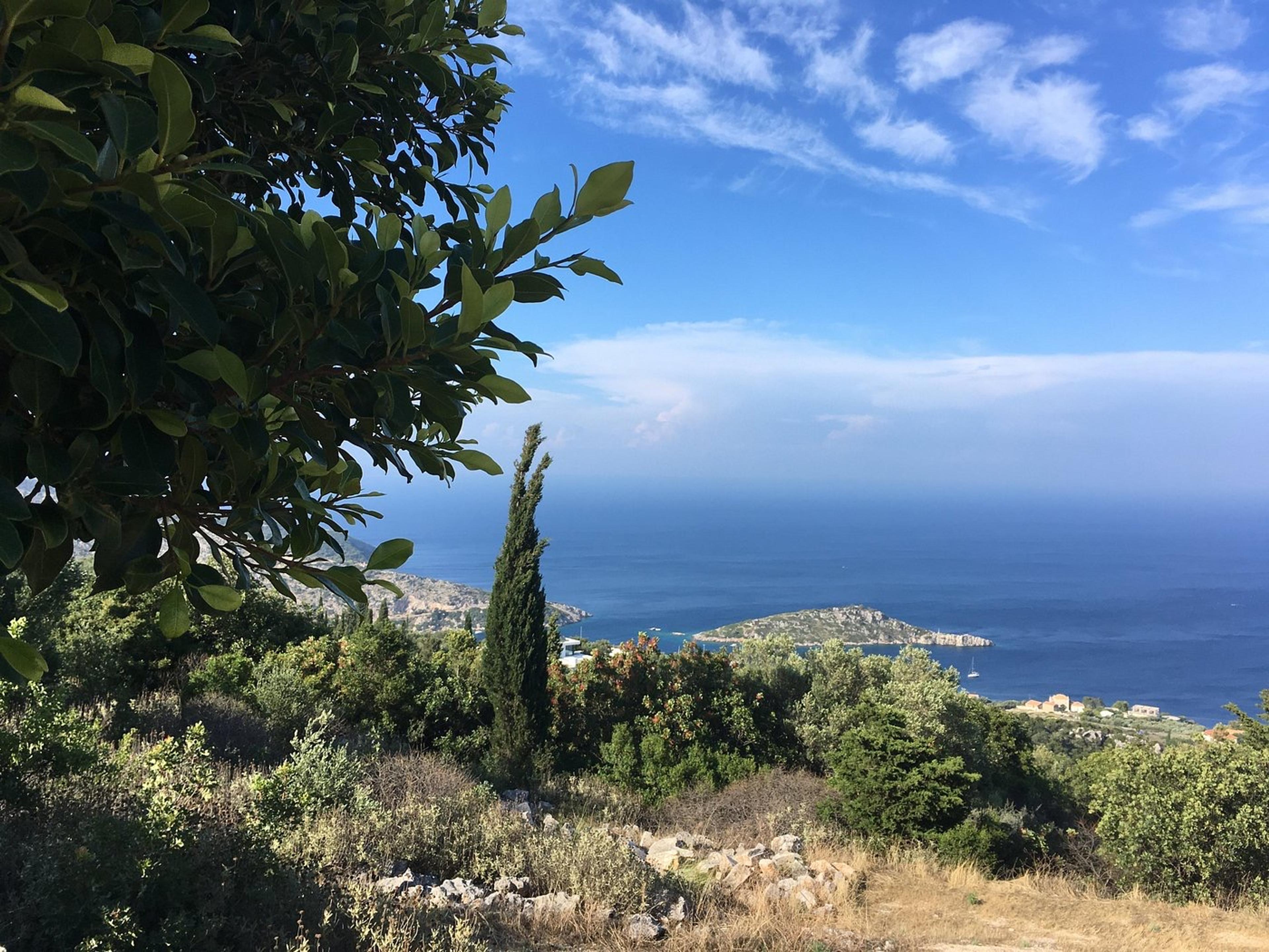 The view from the garden at Askos, over cypresses and scrub down to the sea and the islet off Agios Nikolaos