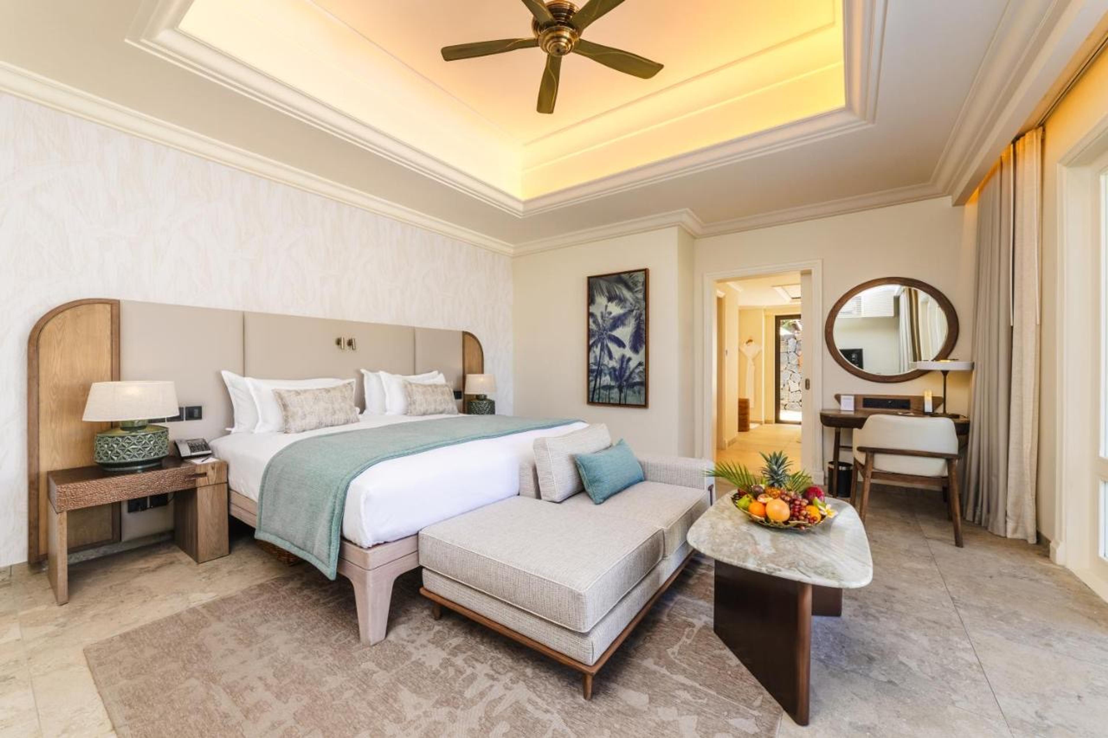 A bedroom with a white bed and a ceiling fan