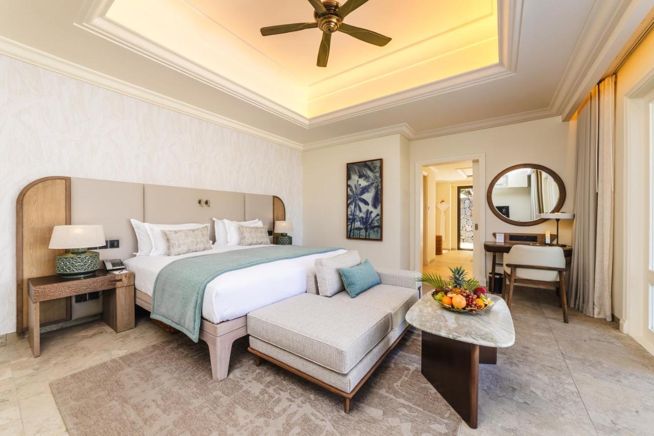 A bedroom with a white bed and a ceiling fan