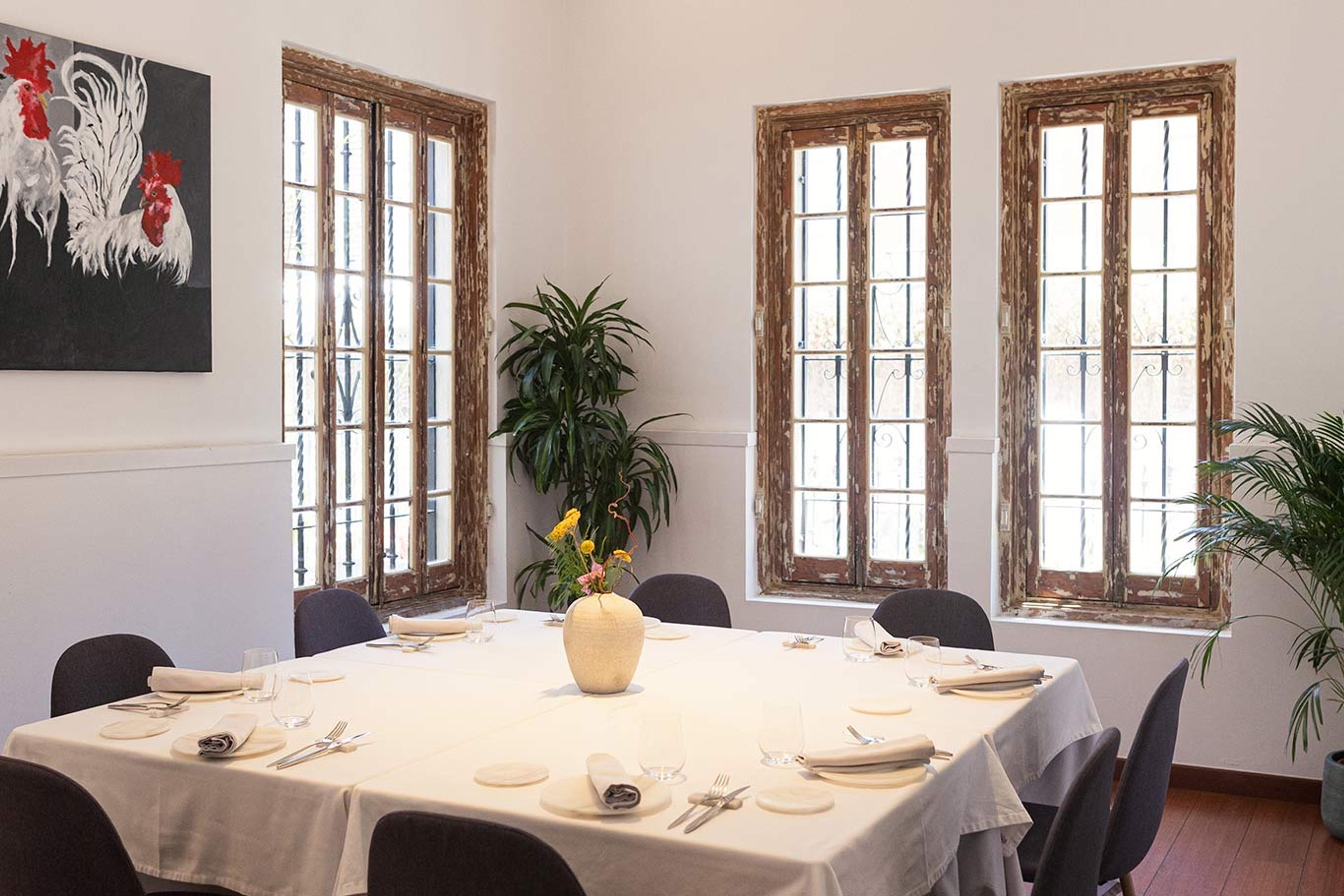 The dining room at Sobretablas, tables laid under tall shuttered windows