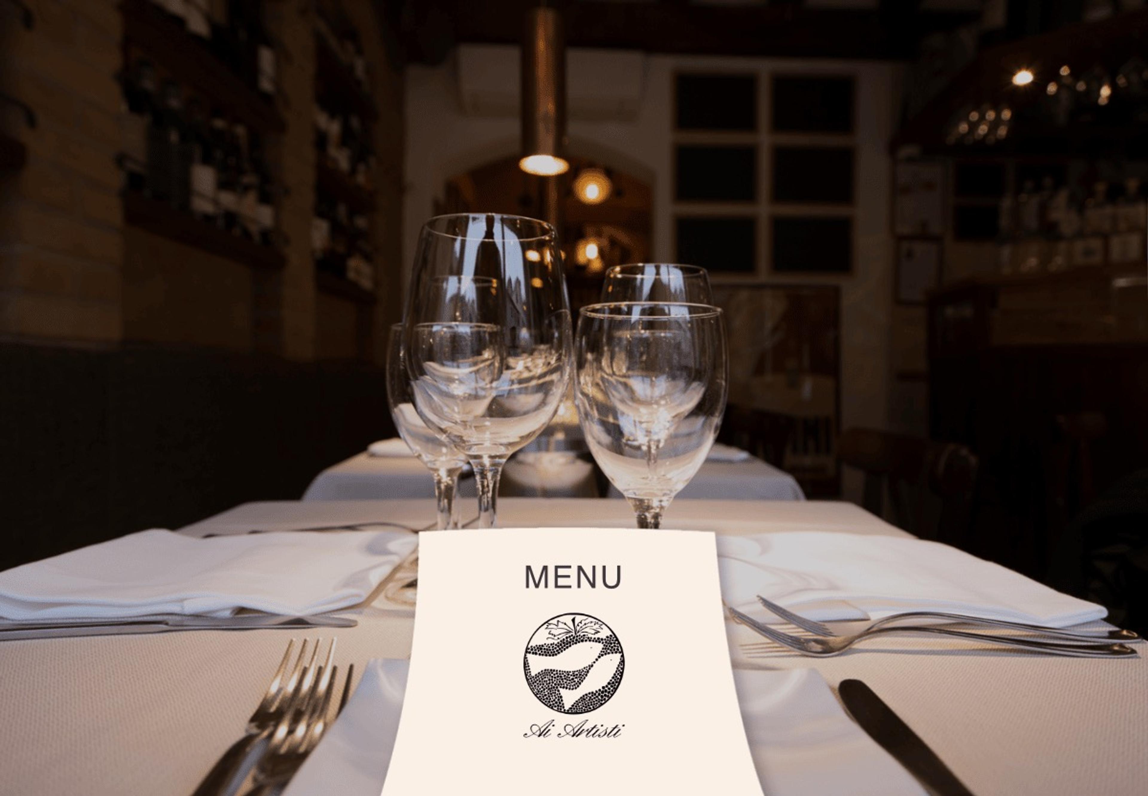 A table laid with wine glasses and a menu card