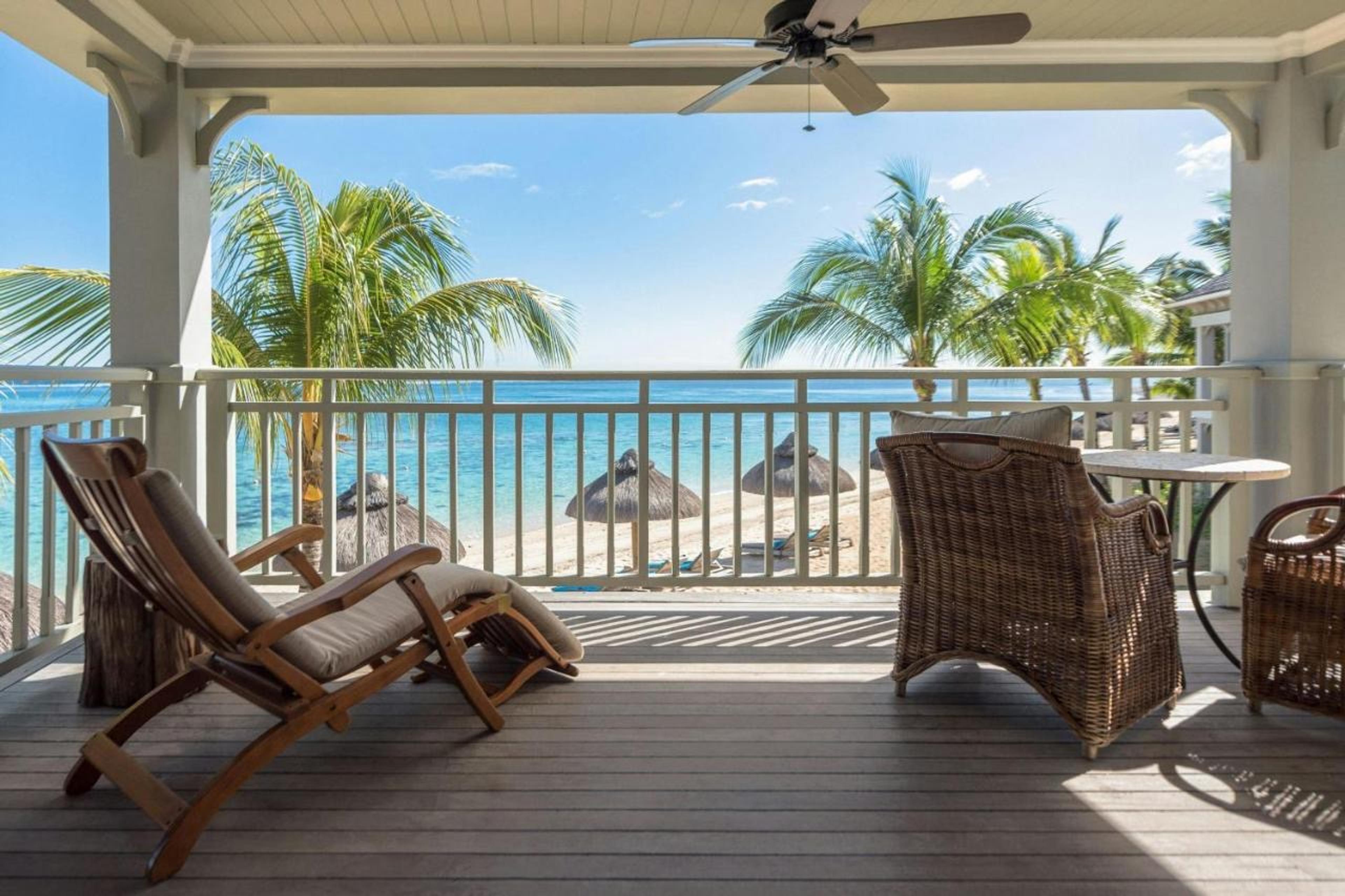 A balcony with loungers facing the beach