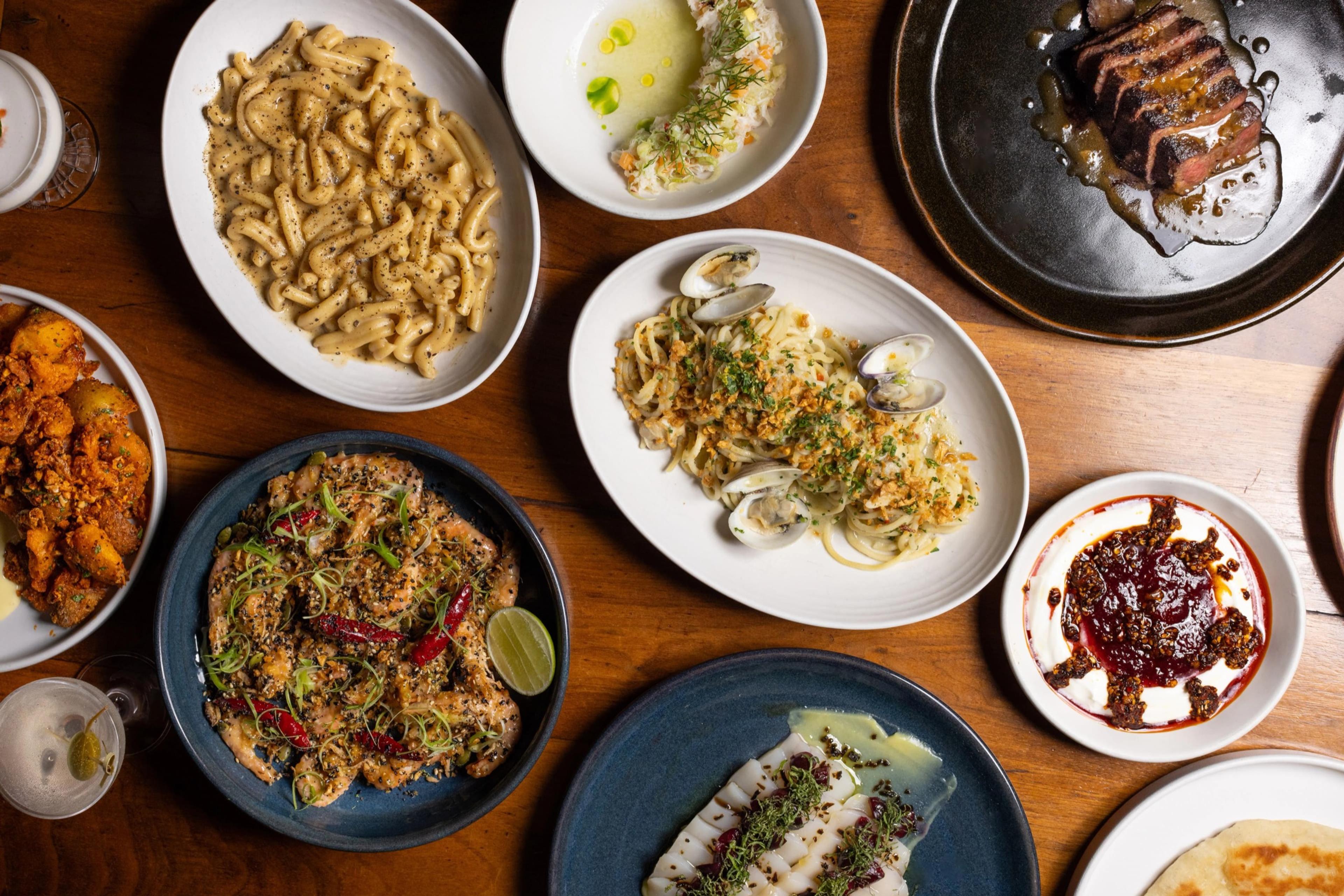 A spread of Majordomo's dishes on a wooden table, seen from above