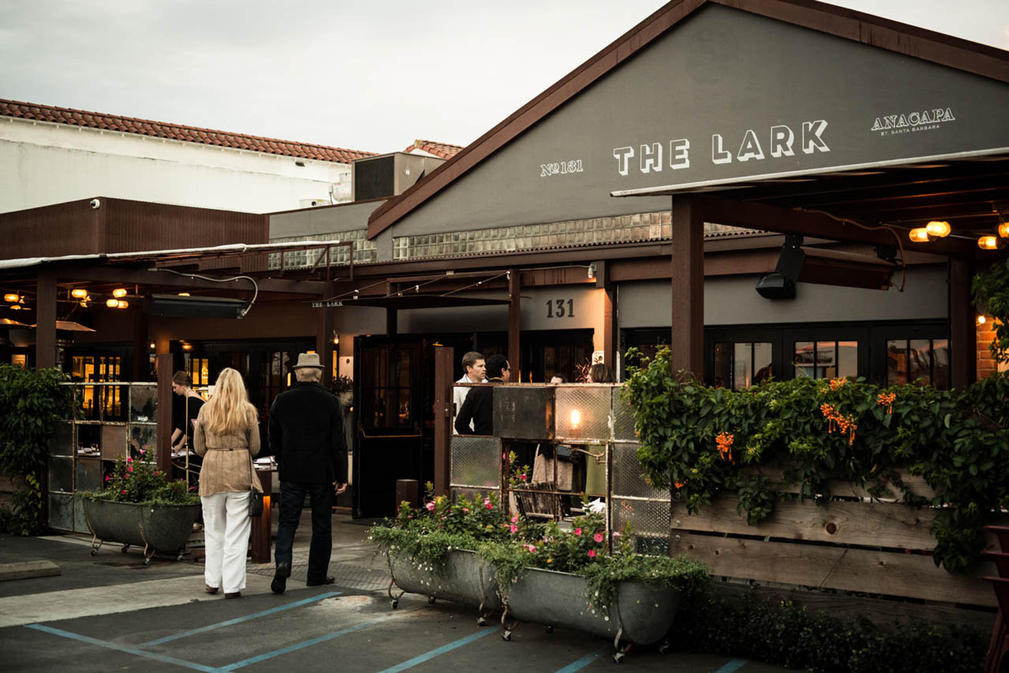 The Lark's covered patio in the Funk Zone, its name painted on the roof edge above the diners