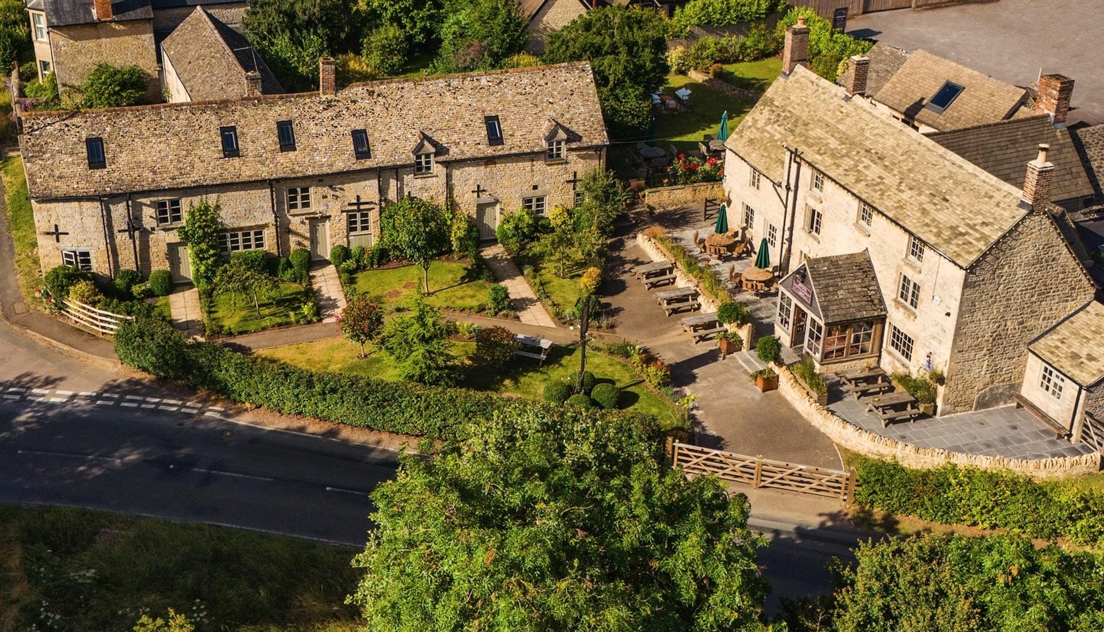 The stone coaching inn and its gardens seen from above