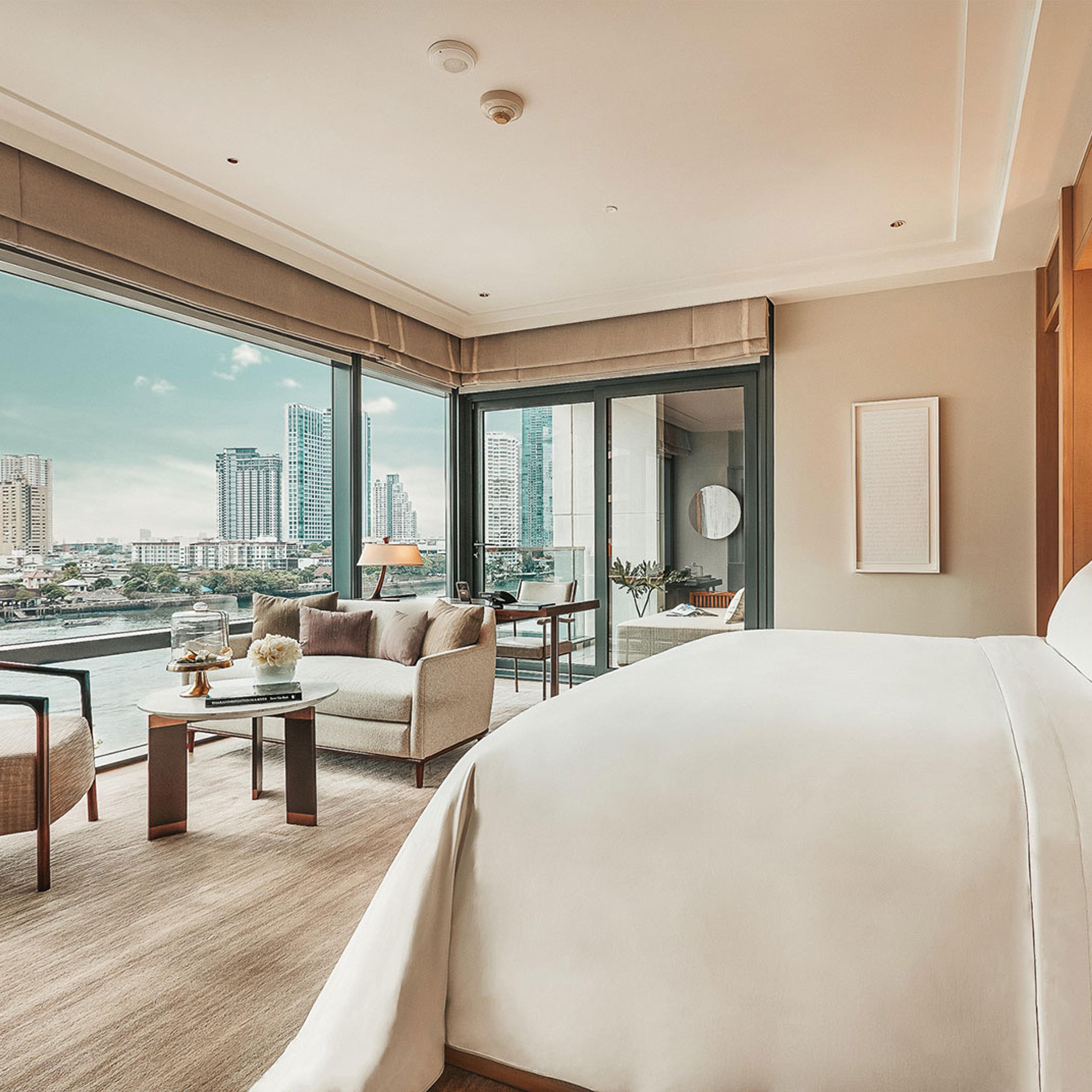 A bedroom with floor-to-ceiling glass onto the river