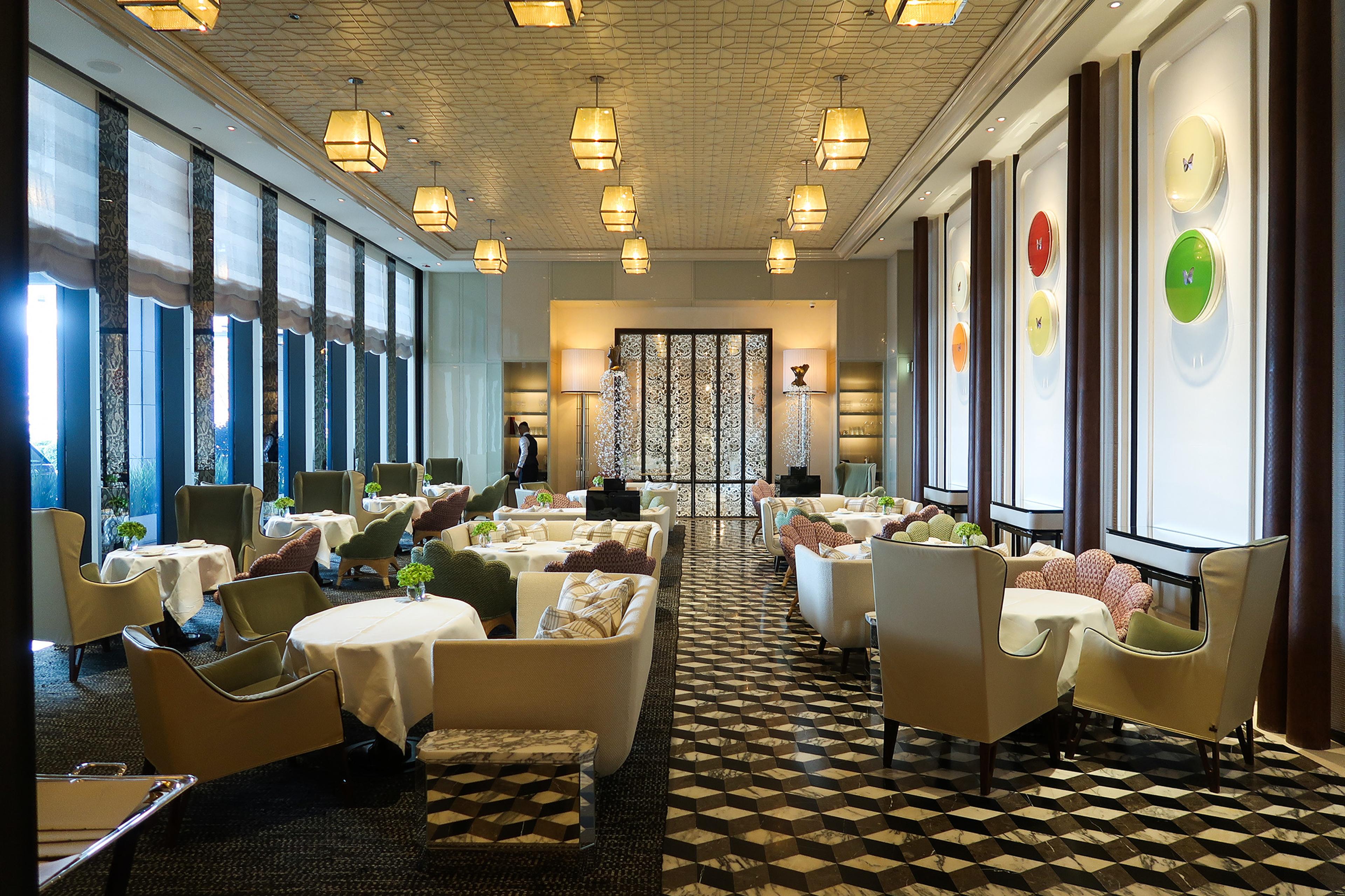 The Butterfly Room, armchairs and small tables under rows of pendant lights