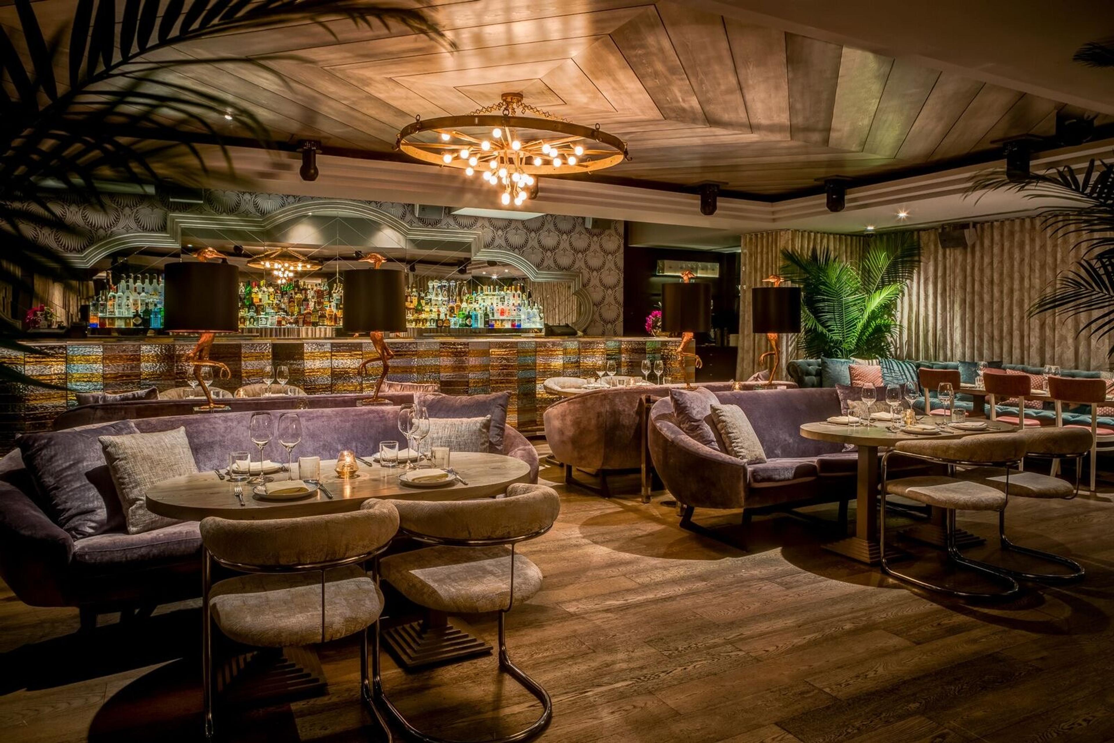 The dining room at Byblos, tables set under warm pendant lights
