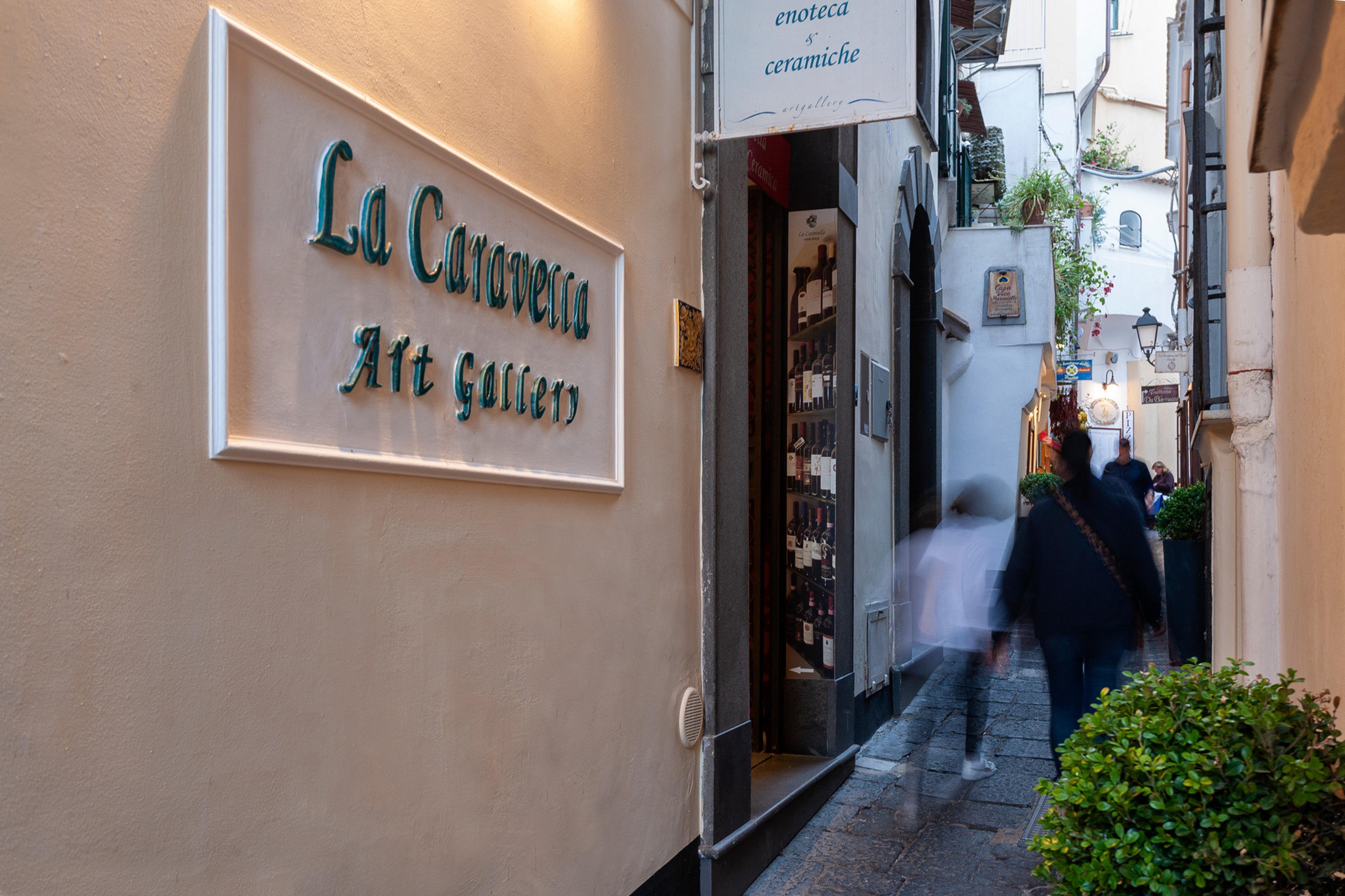La Caravella's sign above a doorway on a narrow whitewashed lane in Amalfi.