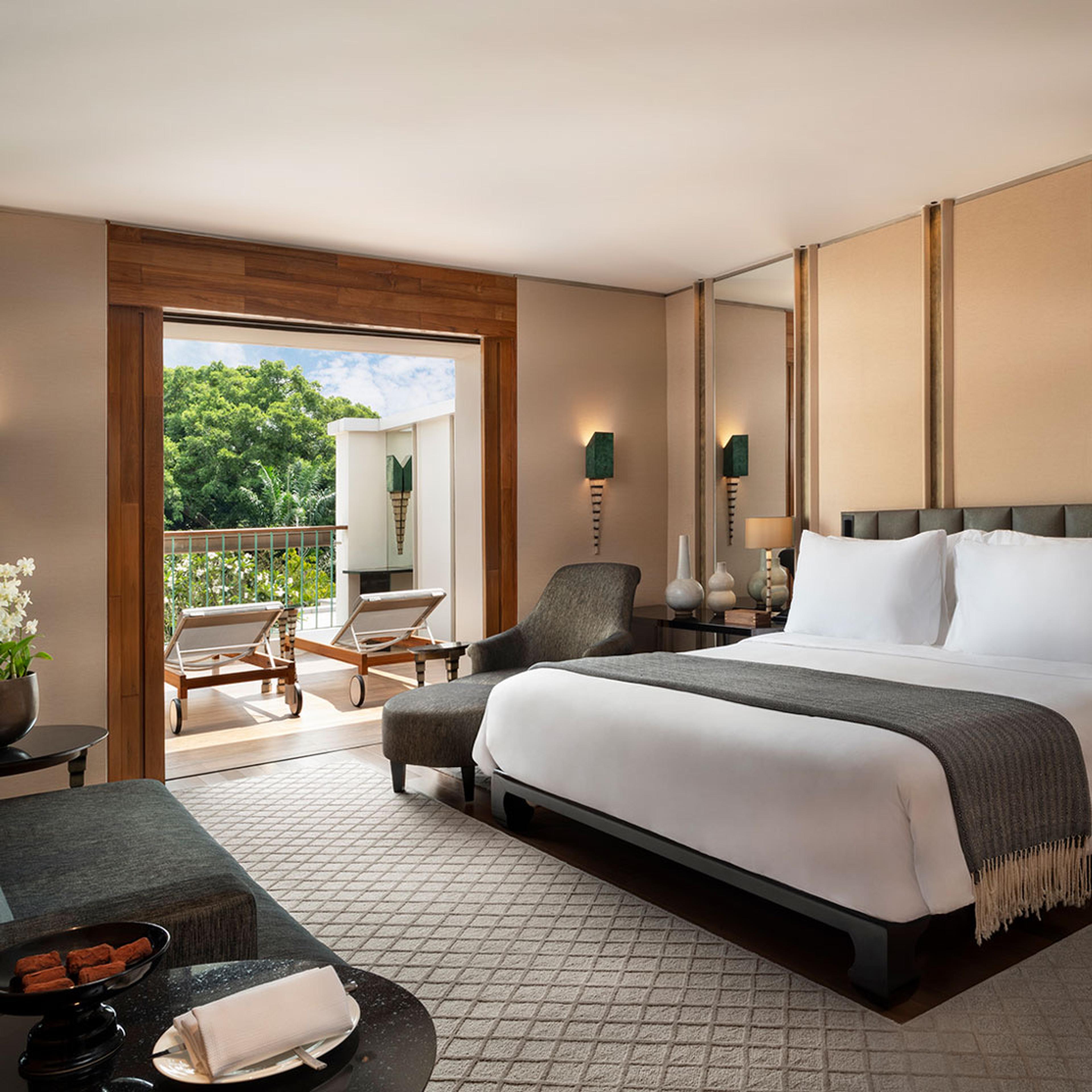 A bedroom with a wide bed beside a tall window