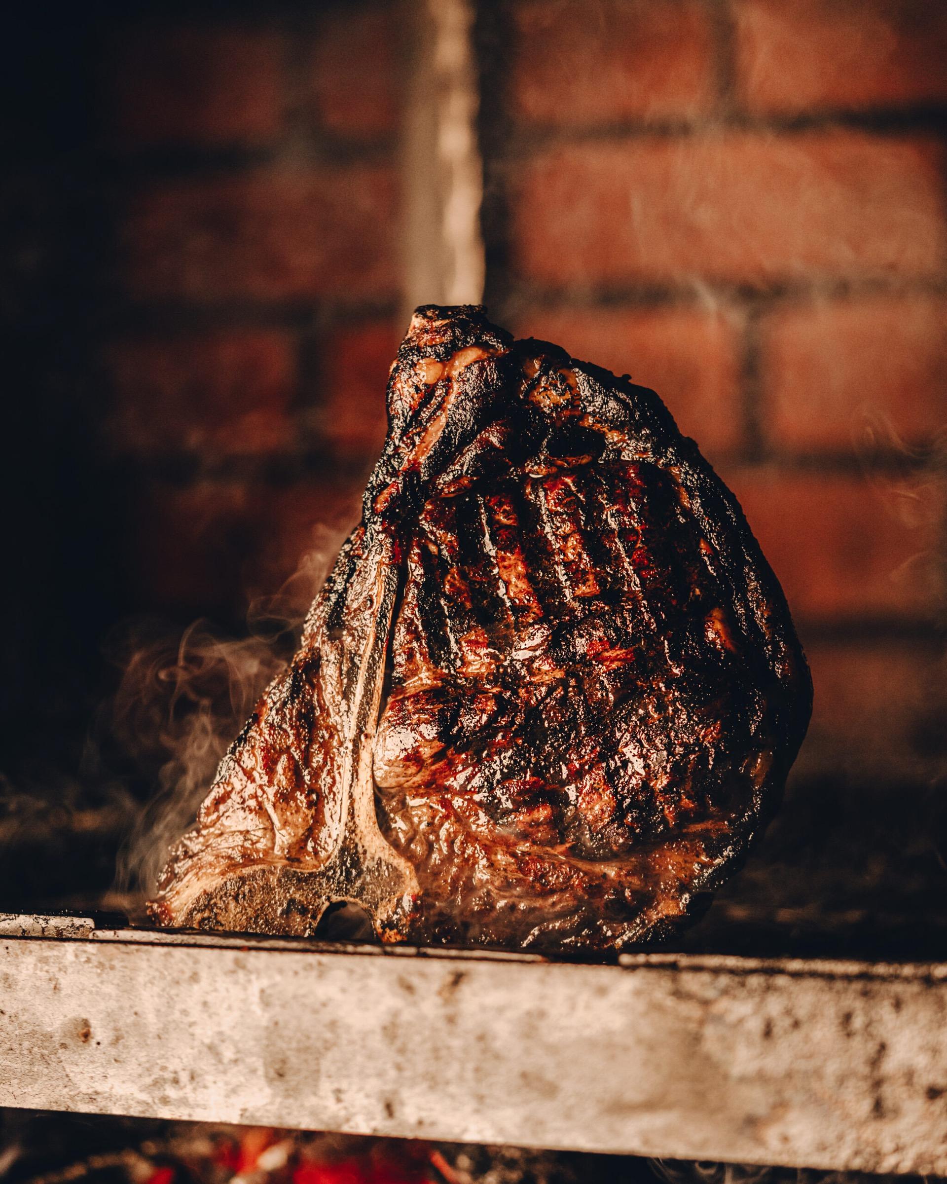 A wood-fired steak at 11 Woodfire, charred at the edges