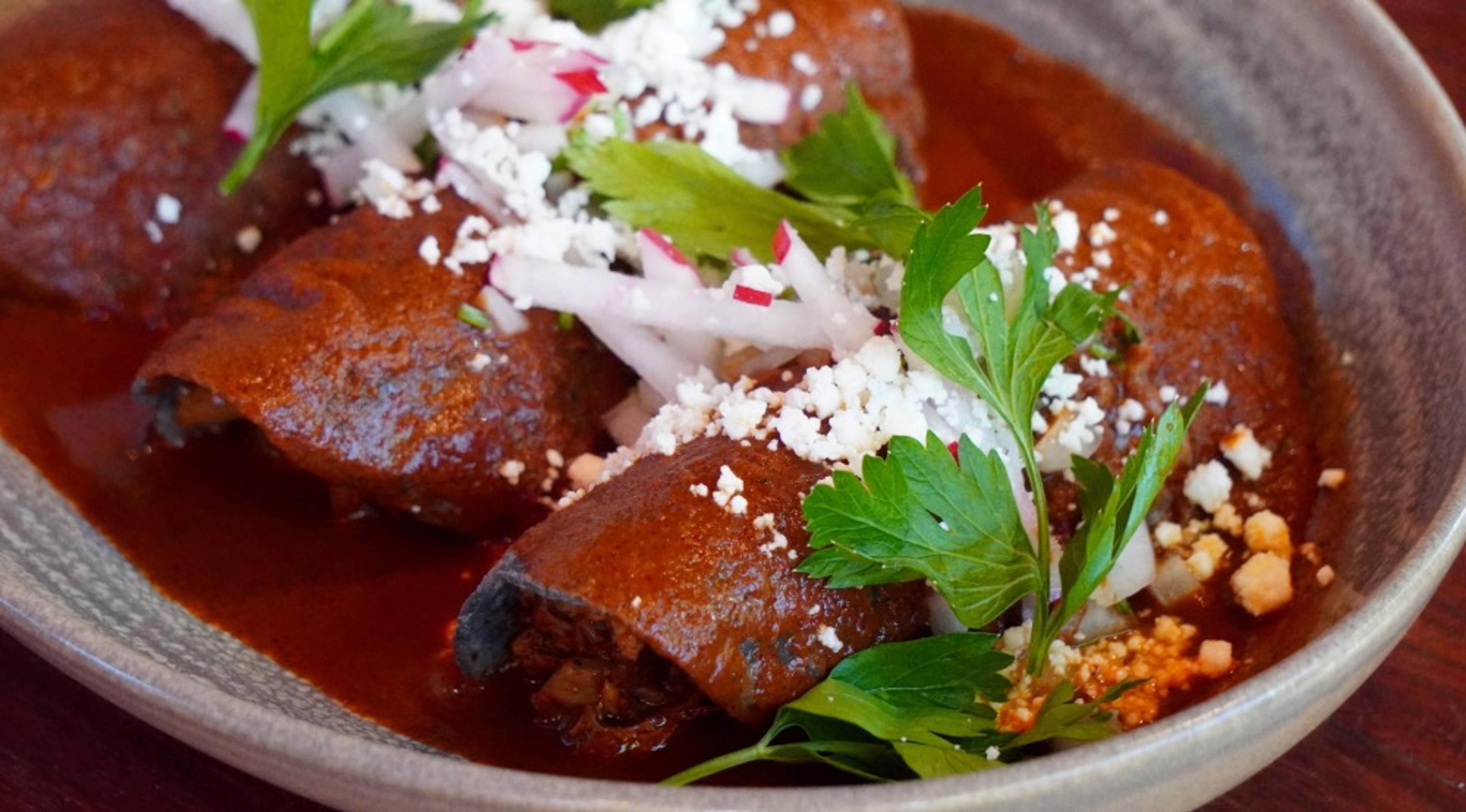 A dish at Frontera Grill, with fresh herbs over a dark sauce