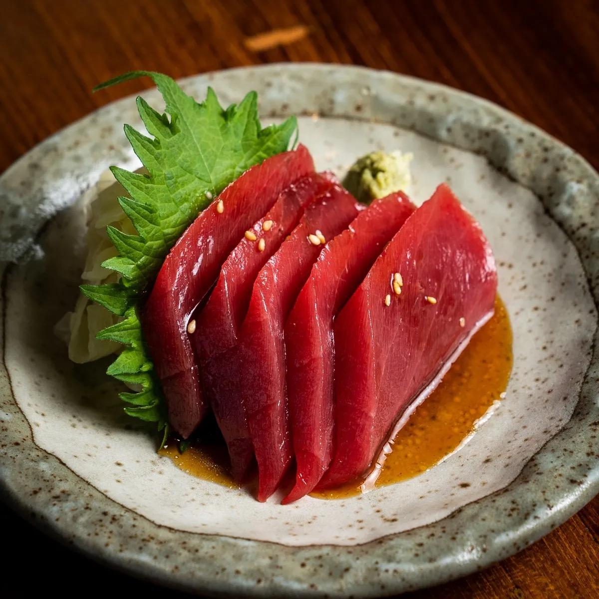 Slices of tuna sashimi in a dark broth at 3Fils