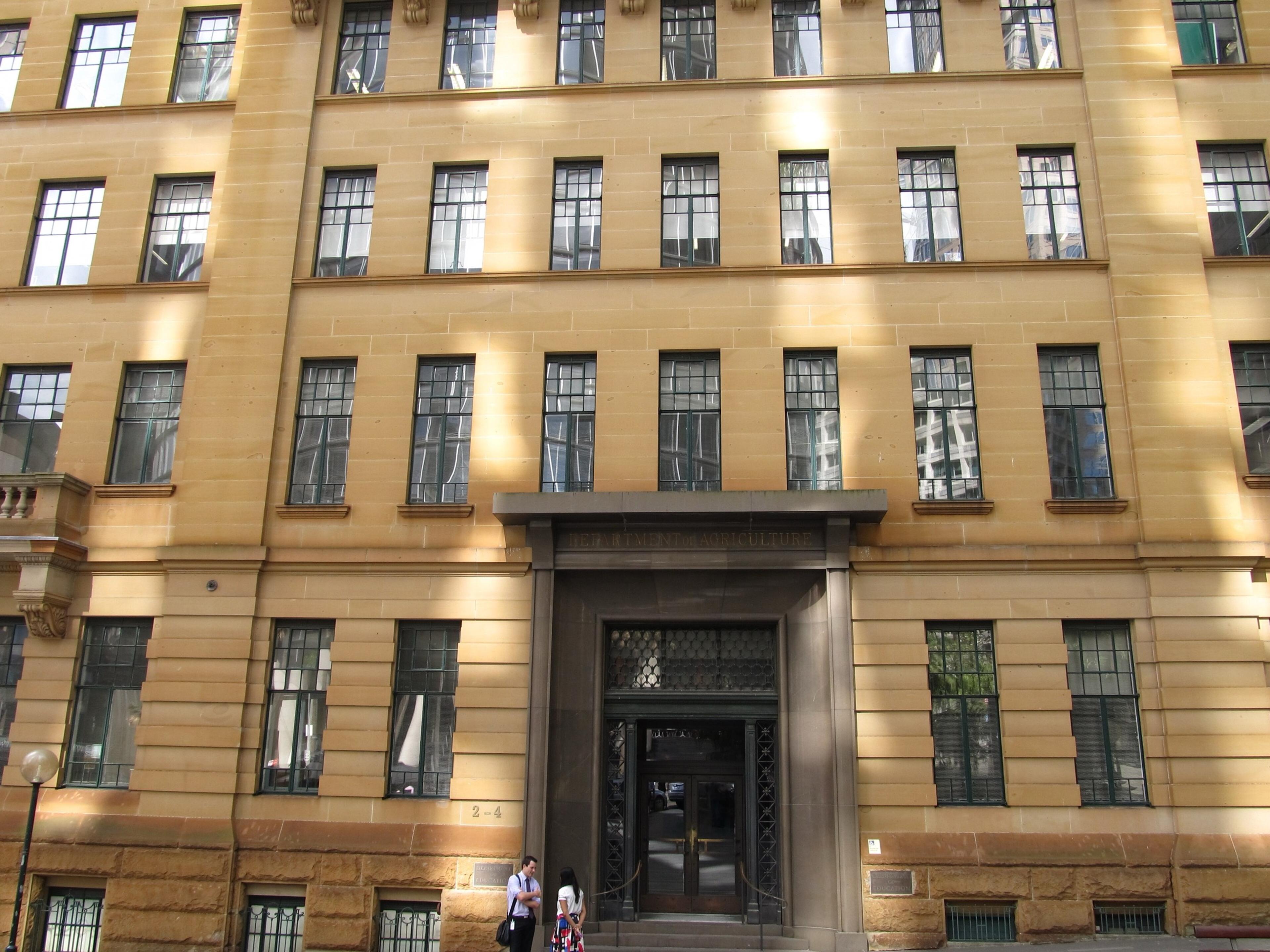The building's upper storeys in honey-coloured sandstone