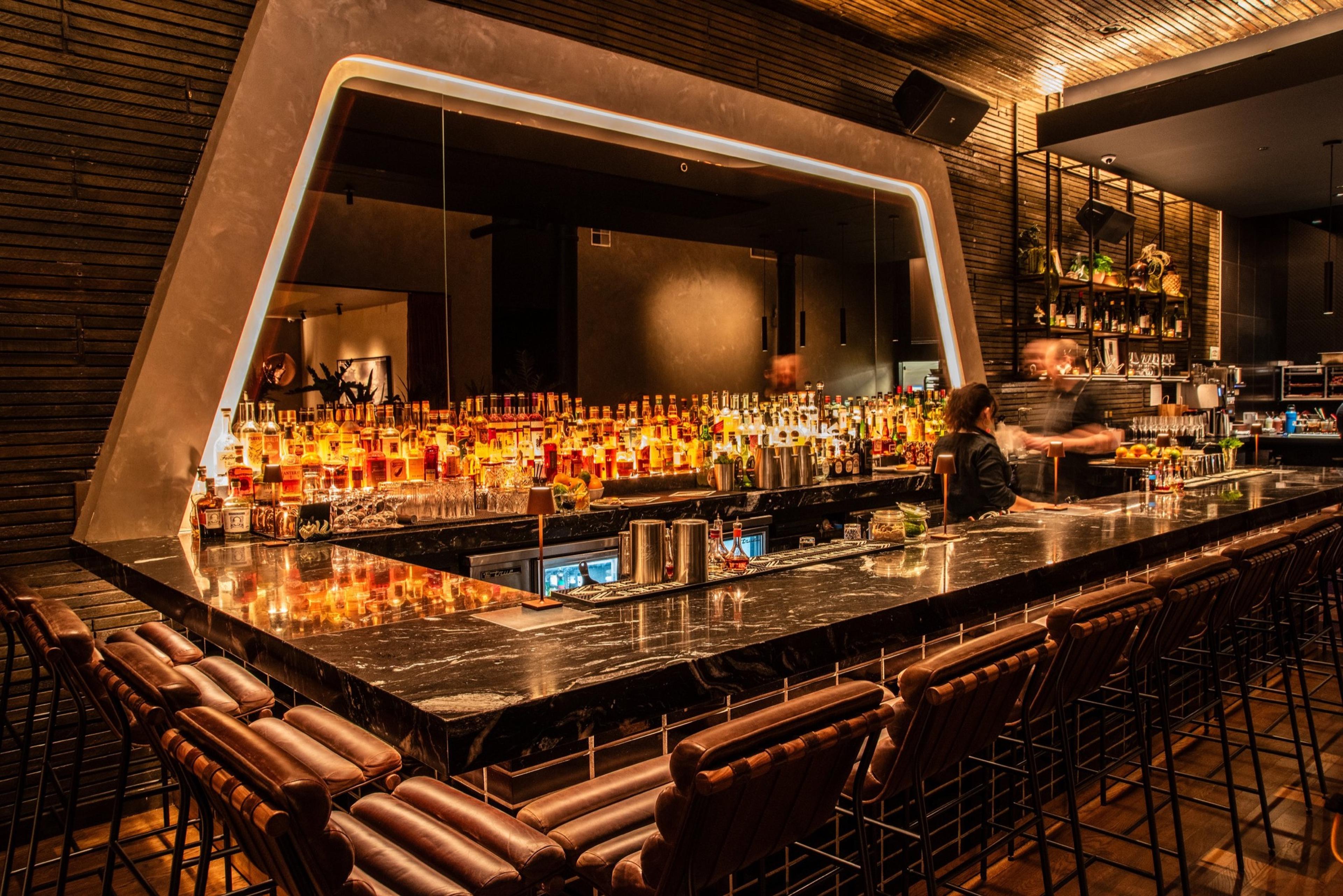 The long bar at El Che Bar in the West Loop, lit low