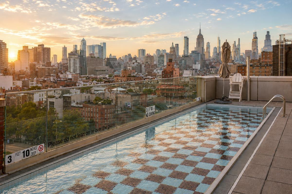 Mr. Purple's rooftop pool deck on the Lower East Side, looking out at the Manhattan skyline at sunset
