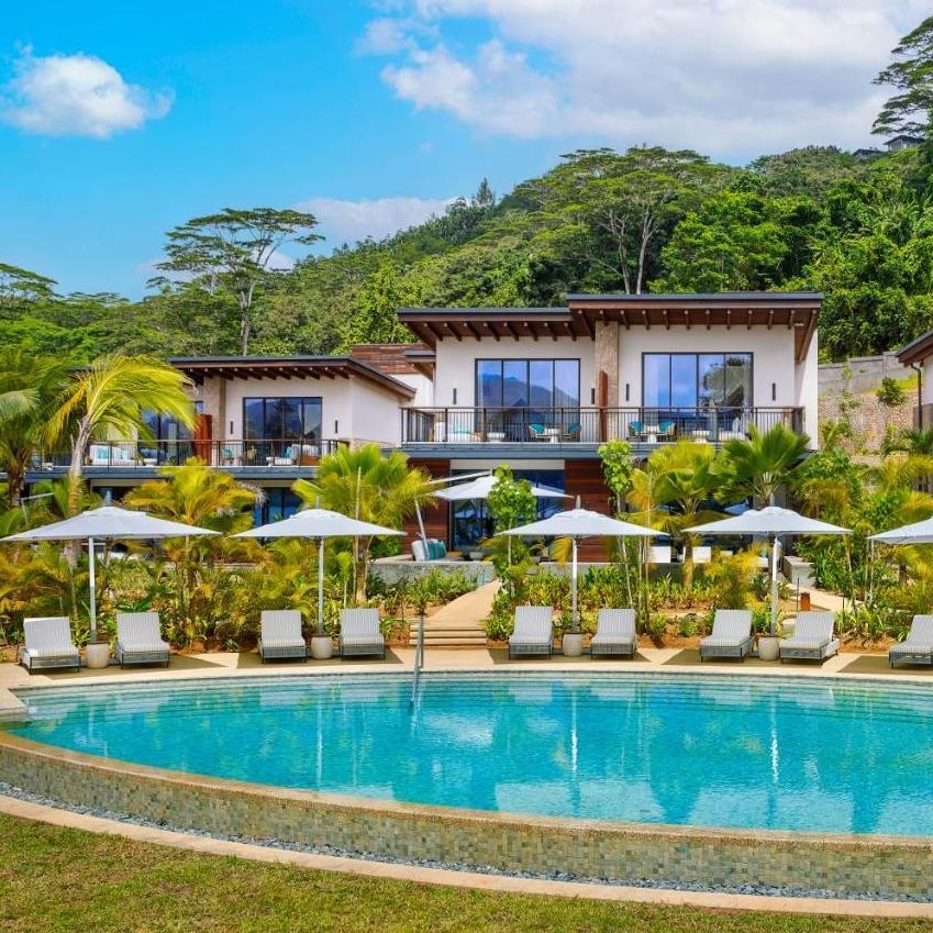 The hotel above its pool, loungers along the edge