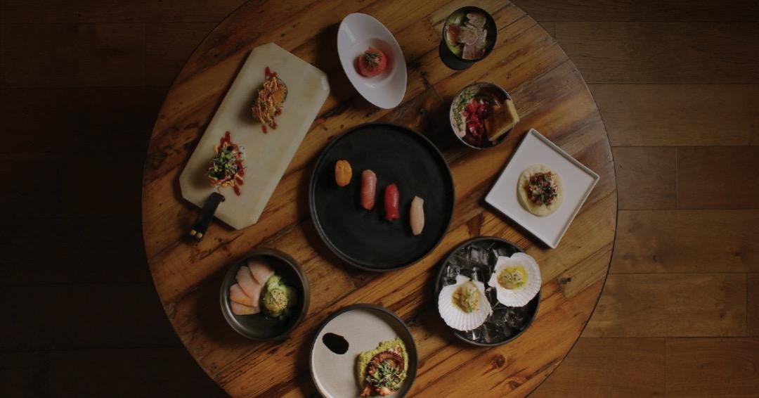 Sushi and small plates on a dark table, seen from above