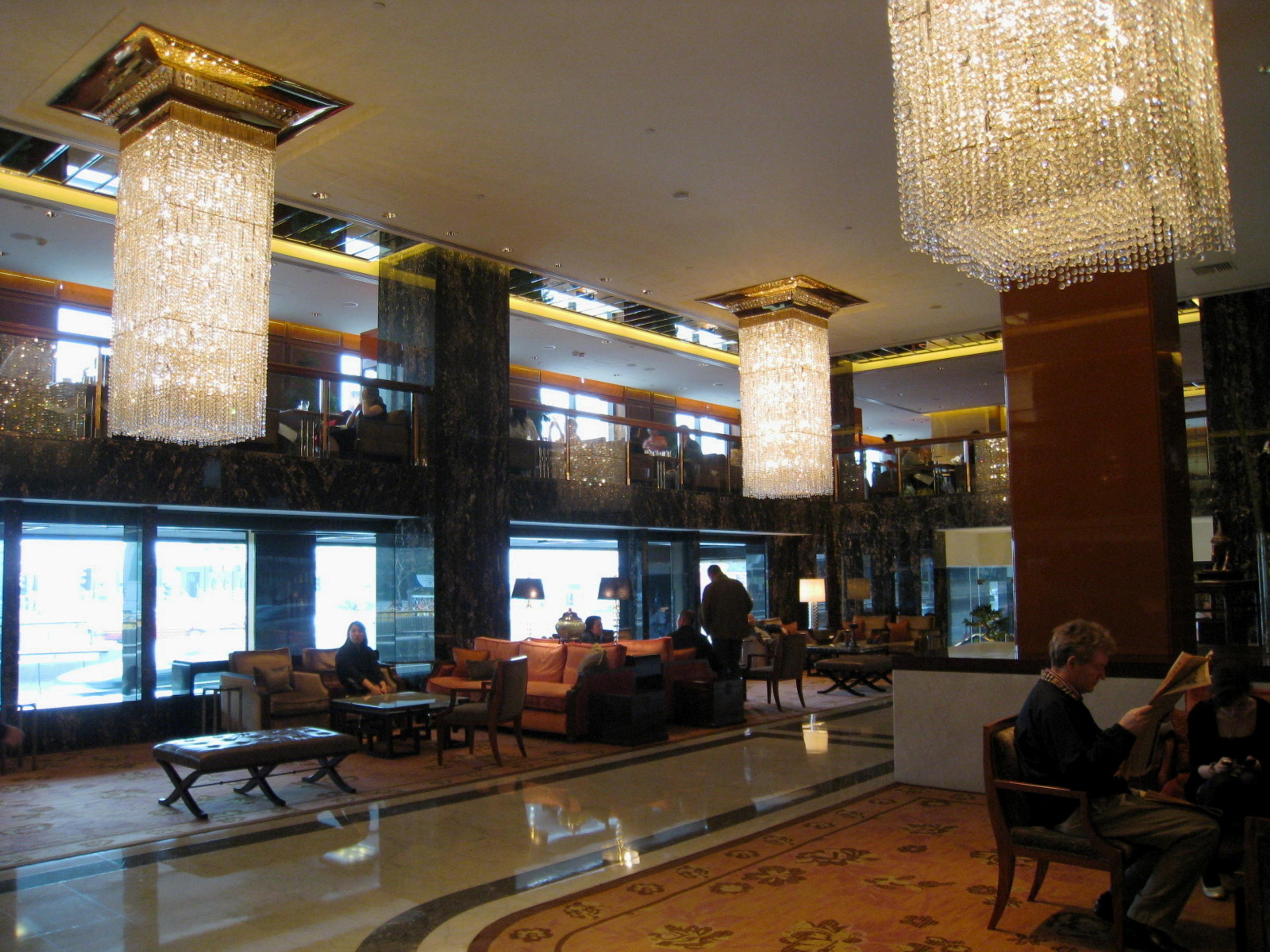 The lobby under crystal chandeliers, with sofas along the windows