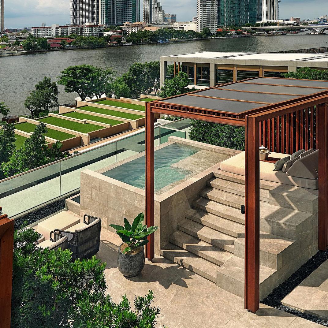 A riverside villa terrace with a plunge pool and a planted garden