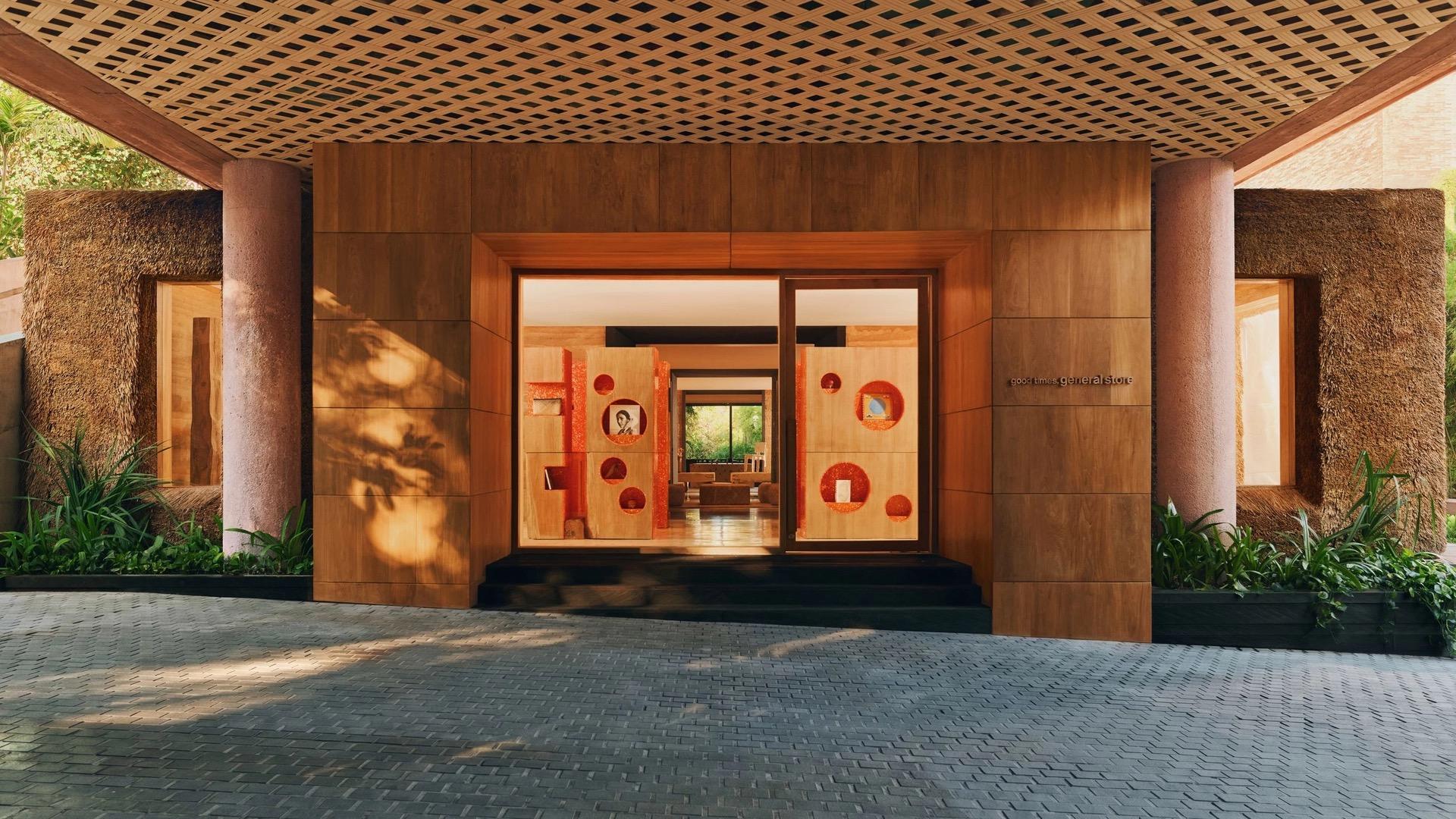 A timber-clad entrance with a lattice roof opens onto a brightly lit general store inside.