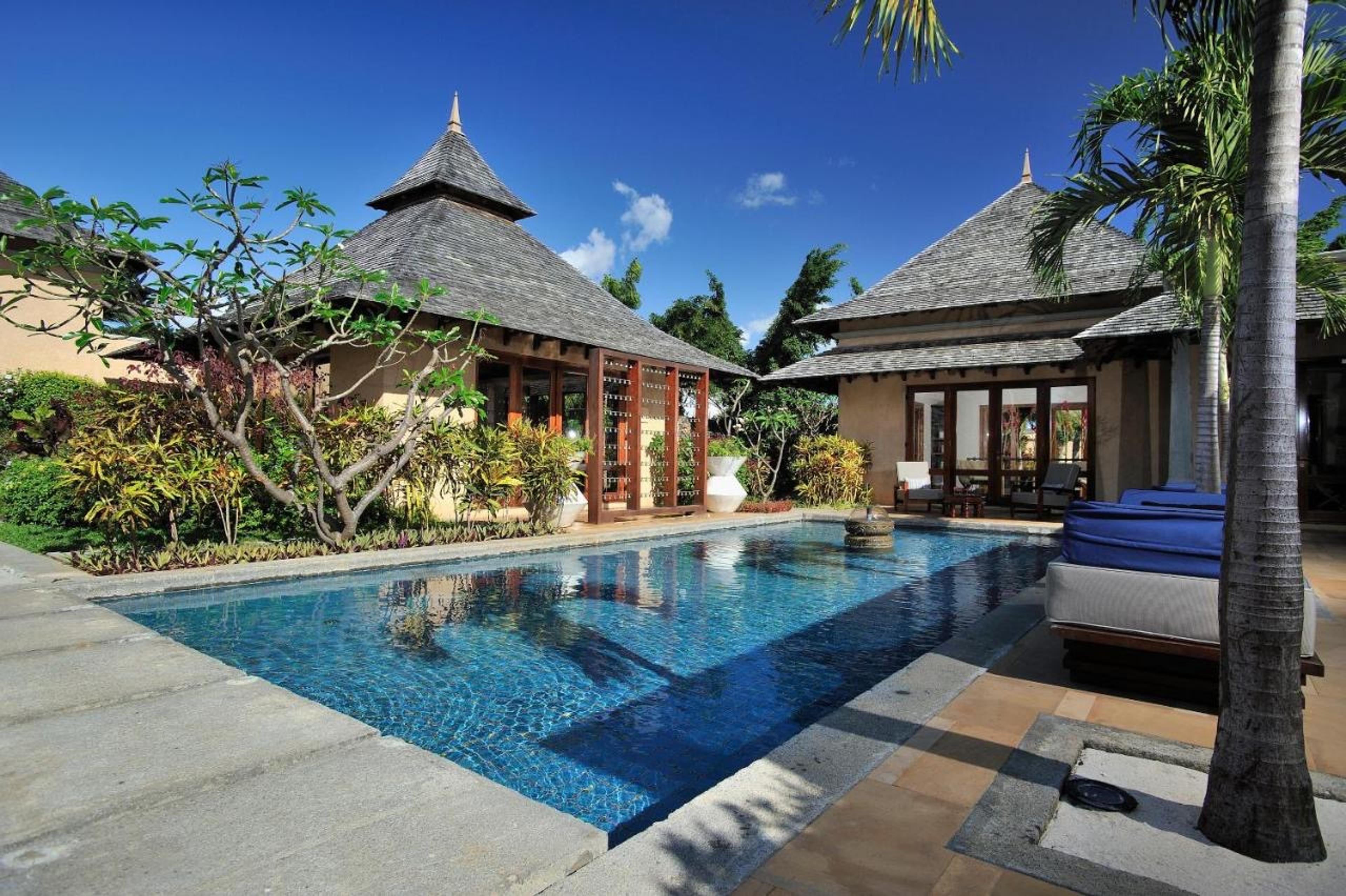 A villa's private pool beside a thatched pavilion
