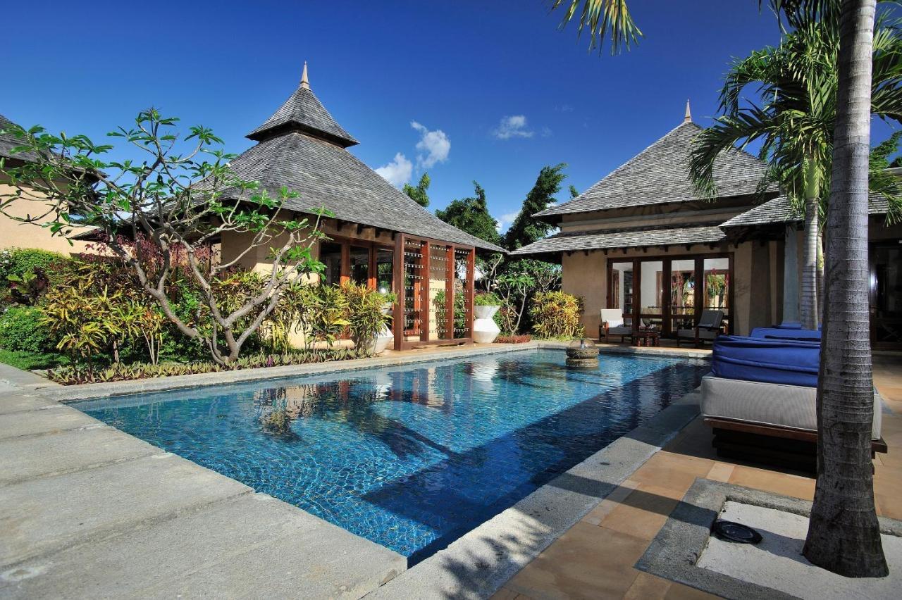 A villa's private pool beside a thatched pavilion