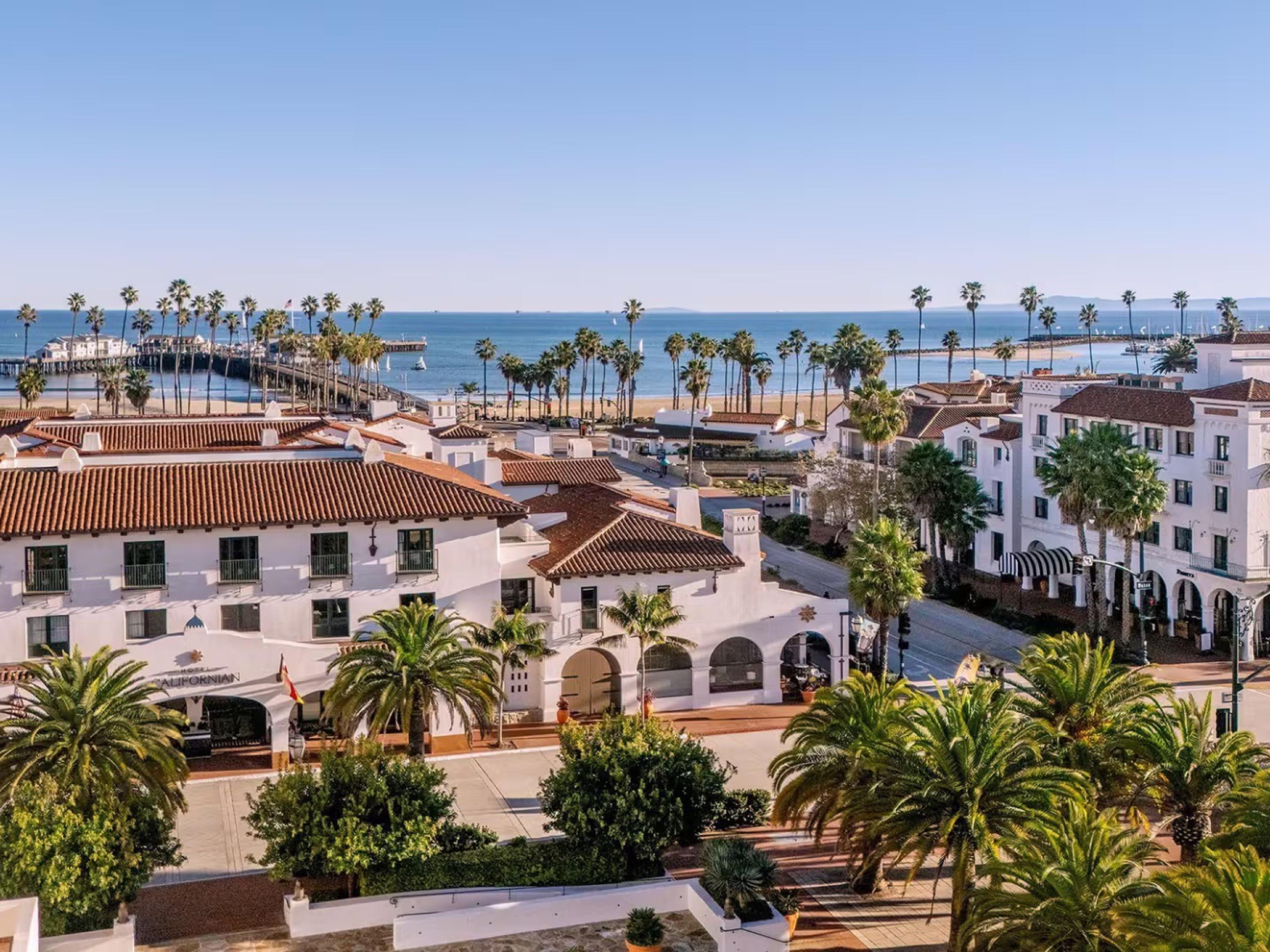 Hotel Californian's white Spanish Revival buildings at the foot of State Street, palms and Stearns Wharf on the Pacific beyond