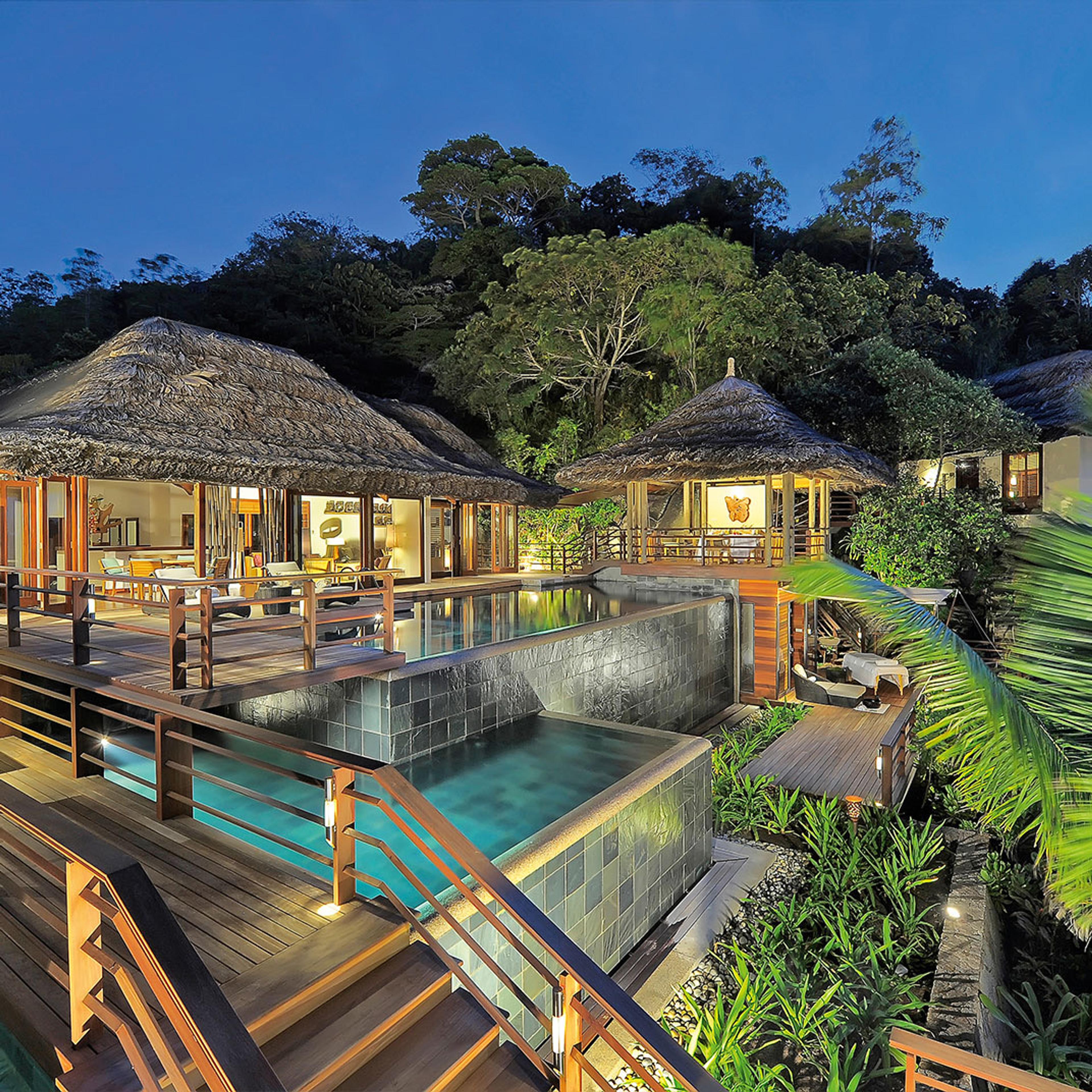 Thatched pavilions above a pool among granite boulders