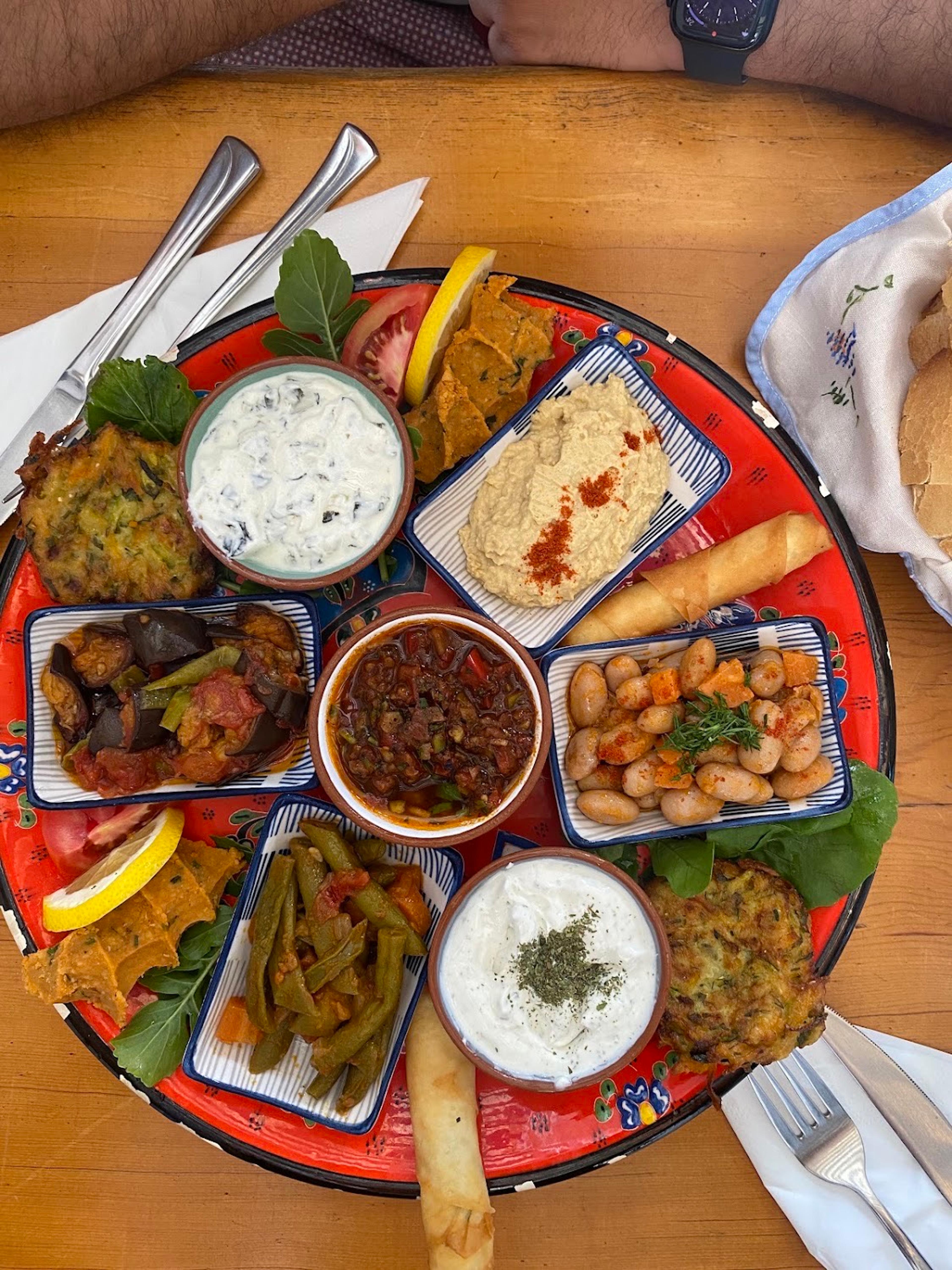 A meze platter at Small House: hummus, cacık, haydari, beans, aubergine and courgette fritters on a painted plate