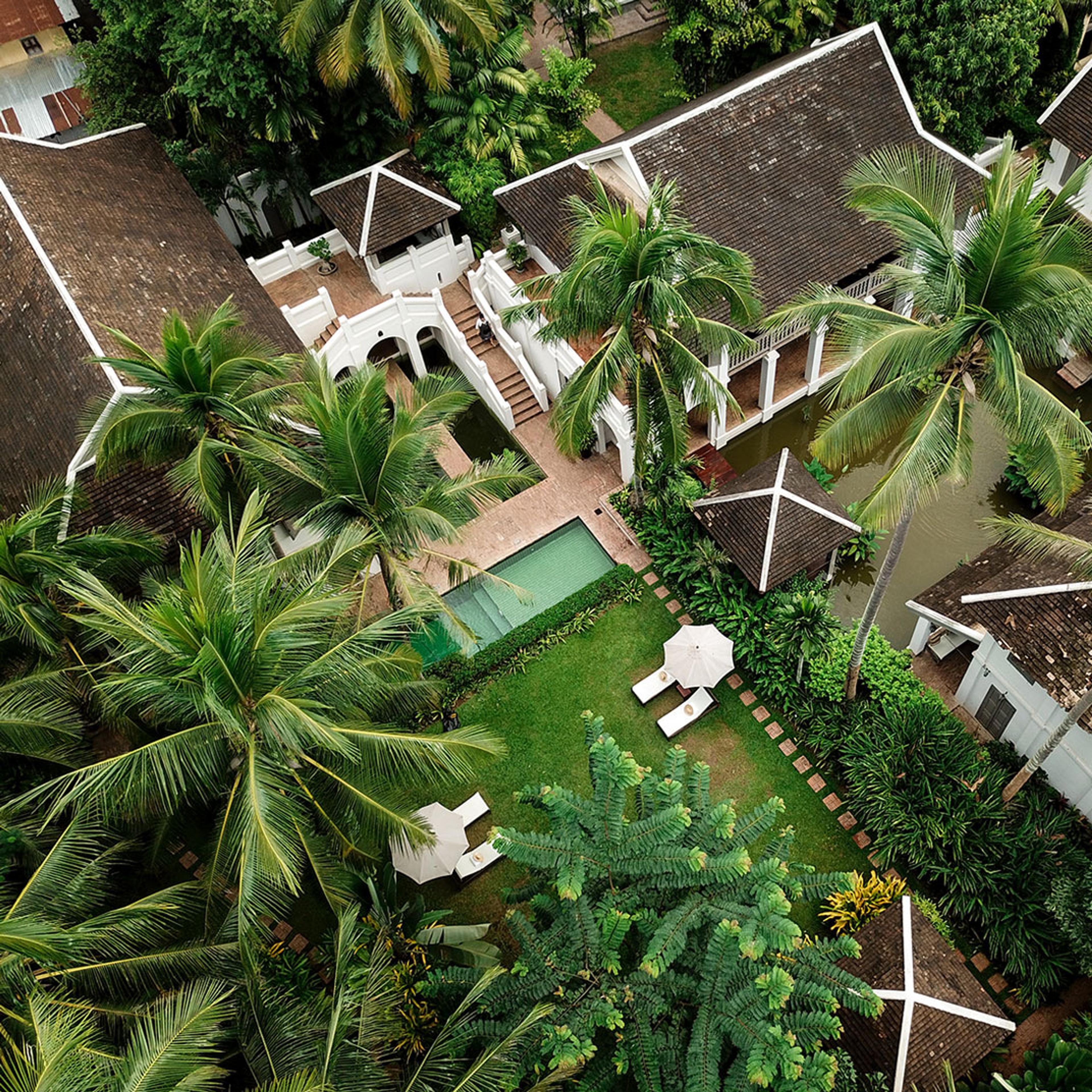 The hotel from above, a pool among palms and tiled roofs