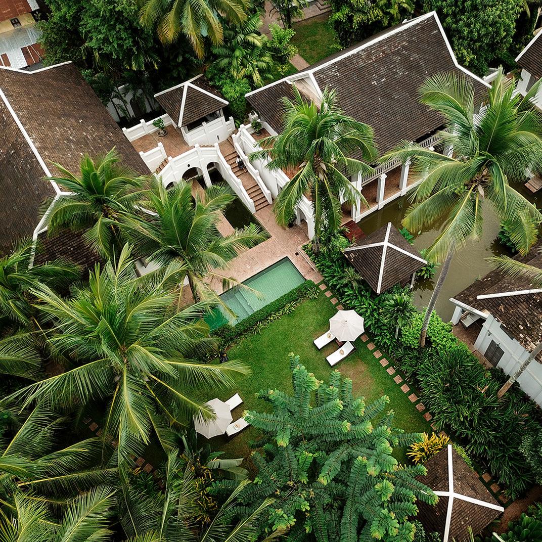 The hotel from above, a pool among palms and tiled roofs
